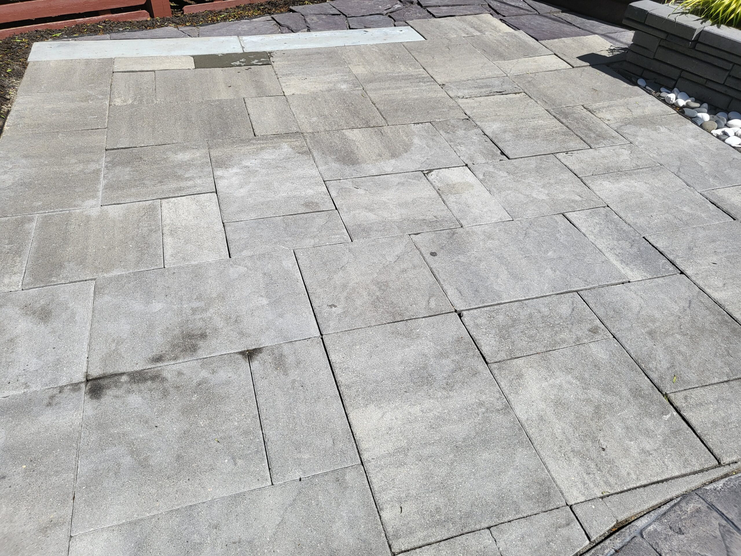 Image displaying the initial state of a slate-stamped concrete patio before the application of Antiquing stain colors, showcasing the raw, untreated surface