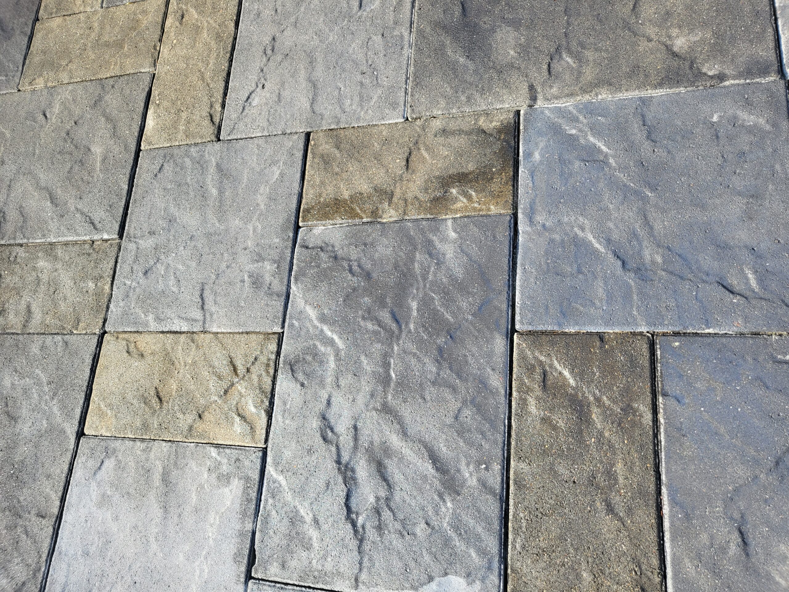 Close-up image highlighting the intricate textures and the harmonious blend of Silver Gray, Light Charcoal, and Tweed Antiquing stains on the slate-stamped concrete patio