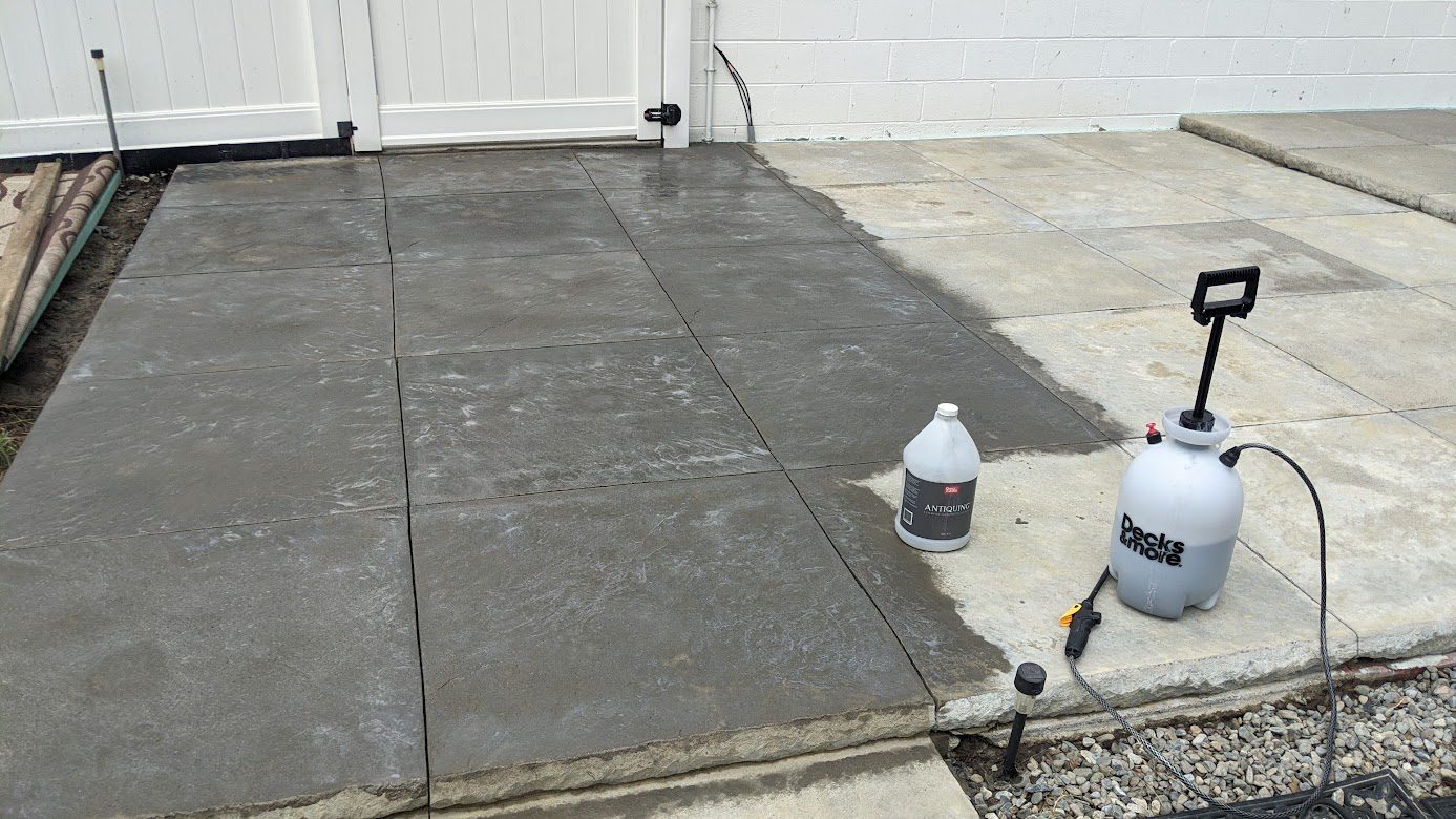 Applying gray stain on concrete patio