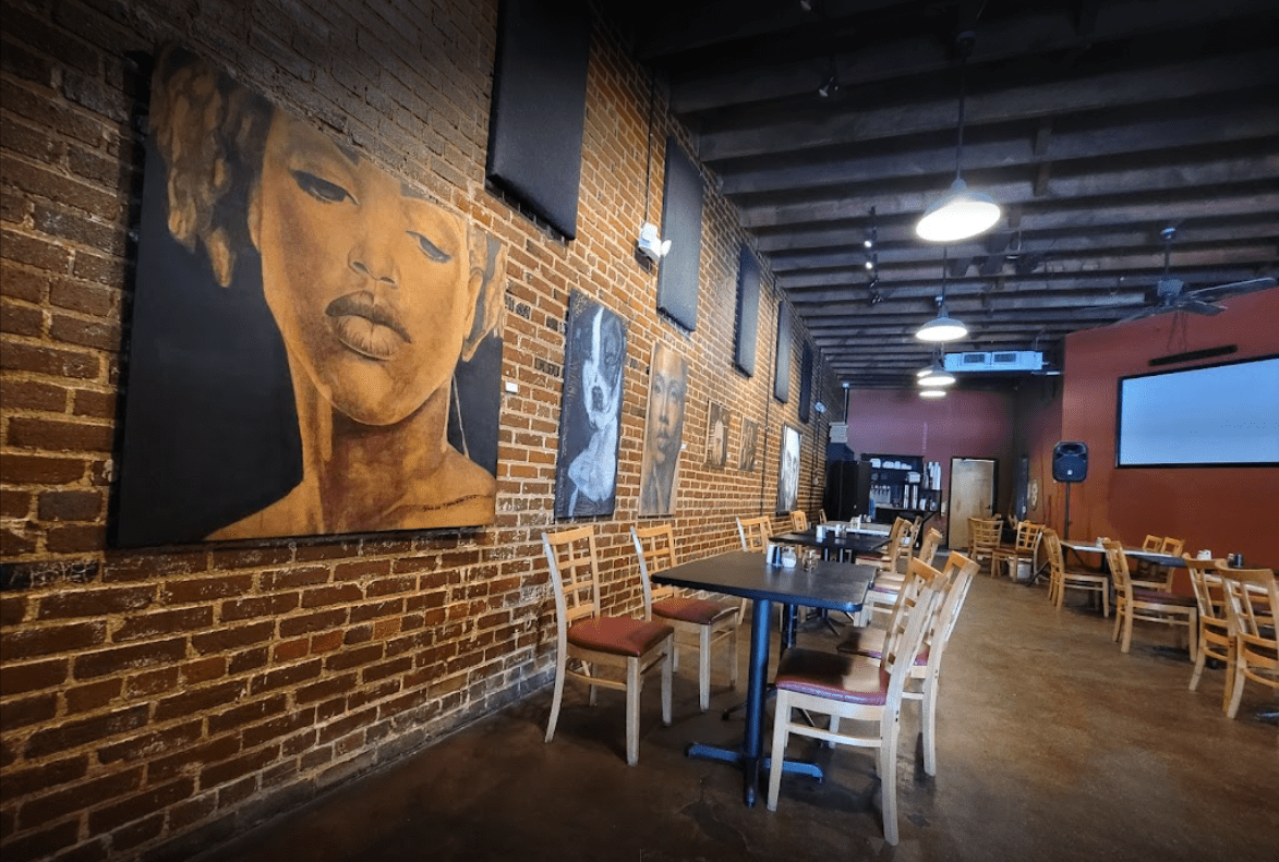 Image showcasing the finished dining area of the pizzeria, with exposed brick walls and vintage posters
