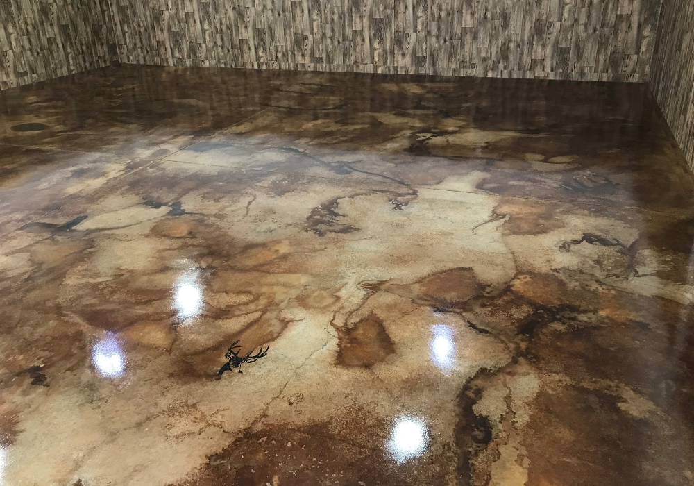 A fully stained and sealed man cave floor with a glossy, marbled finish in warm brown tones