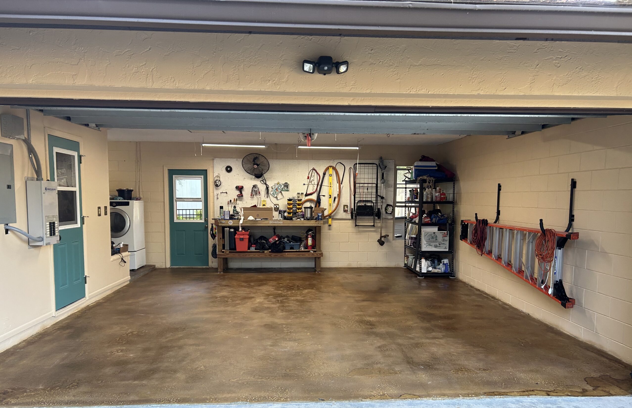 The newly sealed garage floor with an open door for ventilation due to strong VOCs, followed by the successful test of parking cars without peeling or hot tire marks after the coating has cured