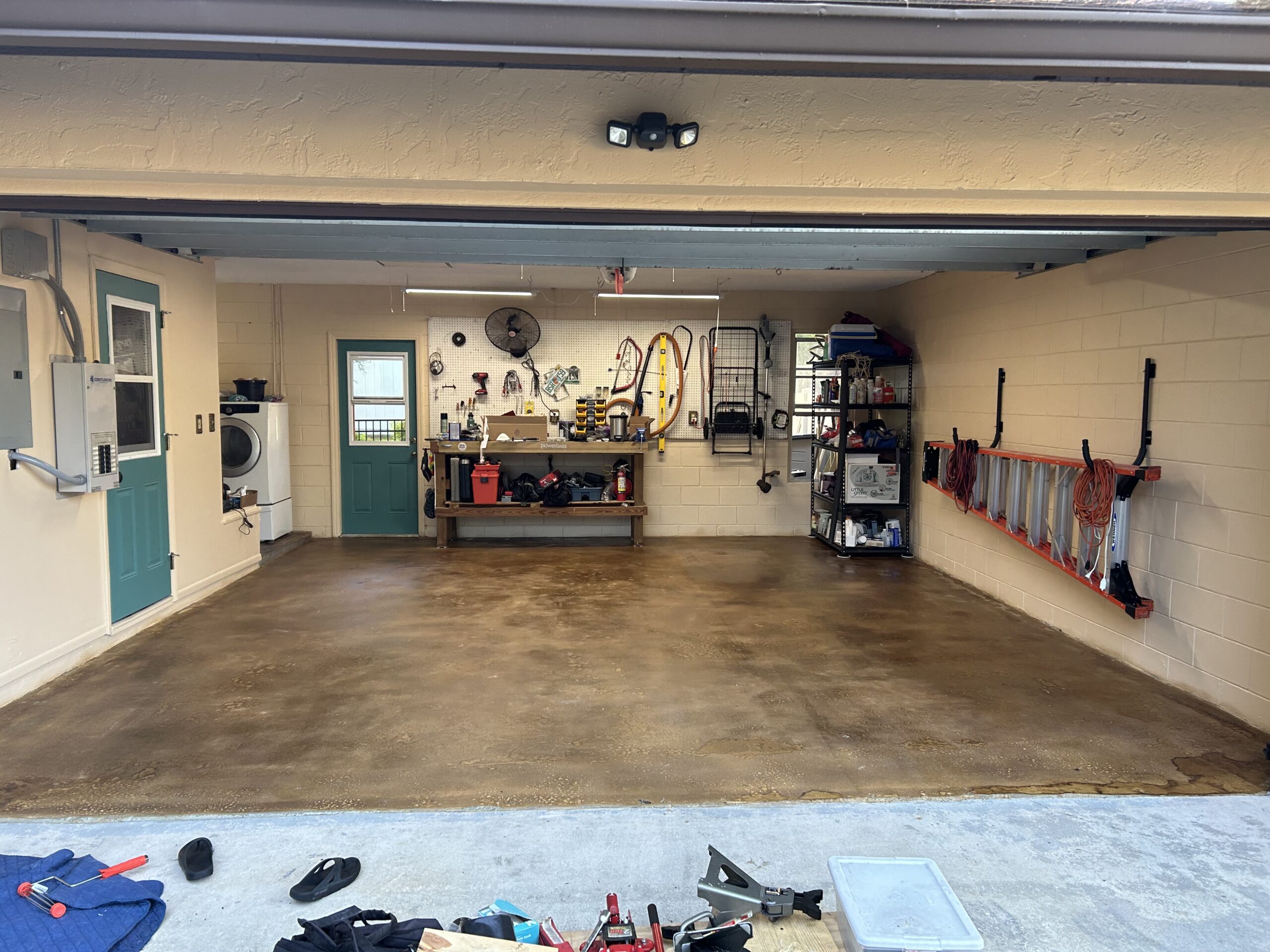 The newly sealed garage floor with an open door for ventilation due to strong VOCs, followed by the successful test of parking cars without peeling or hot tire marks after the coating has cured