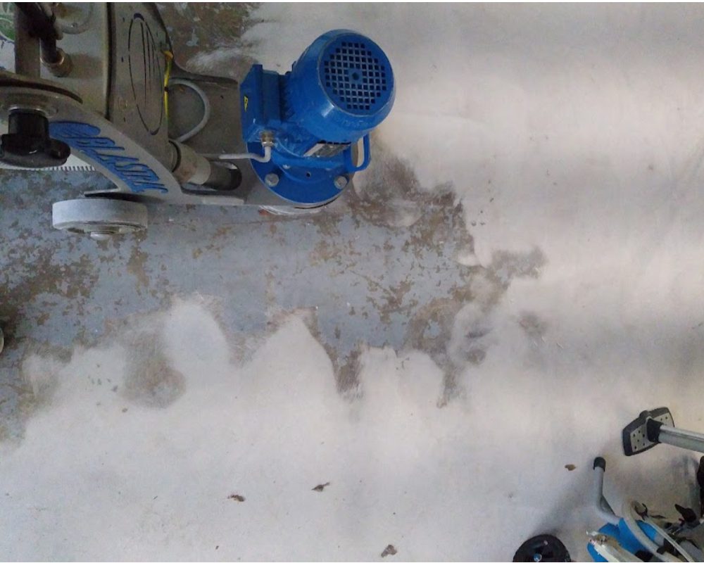 Rented concrete grinder to laboriously remove the deteriorating coating from the garage floor over the course of two days