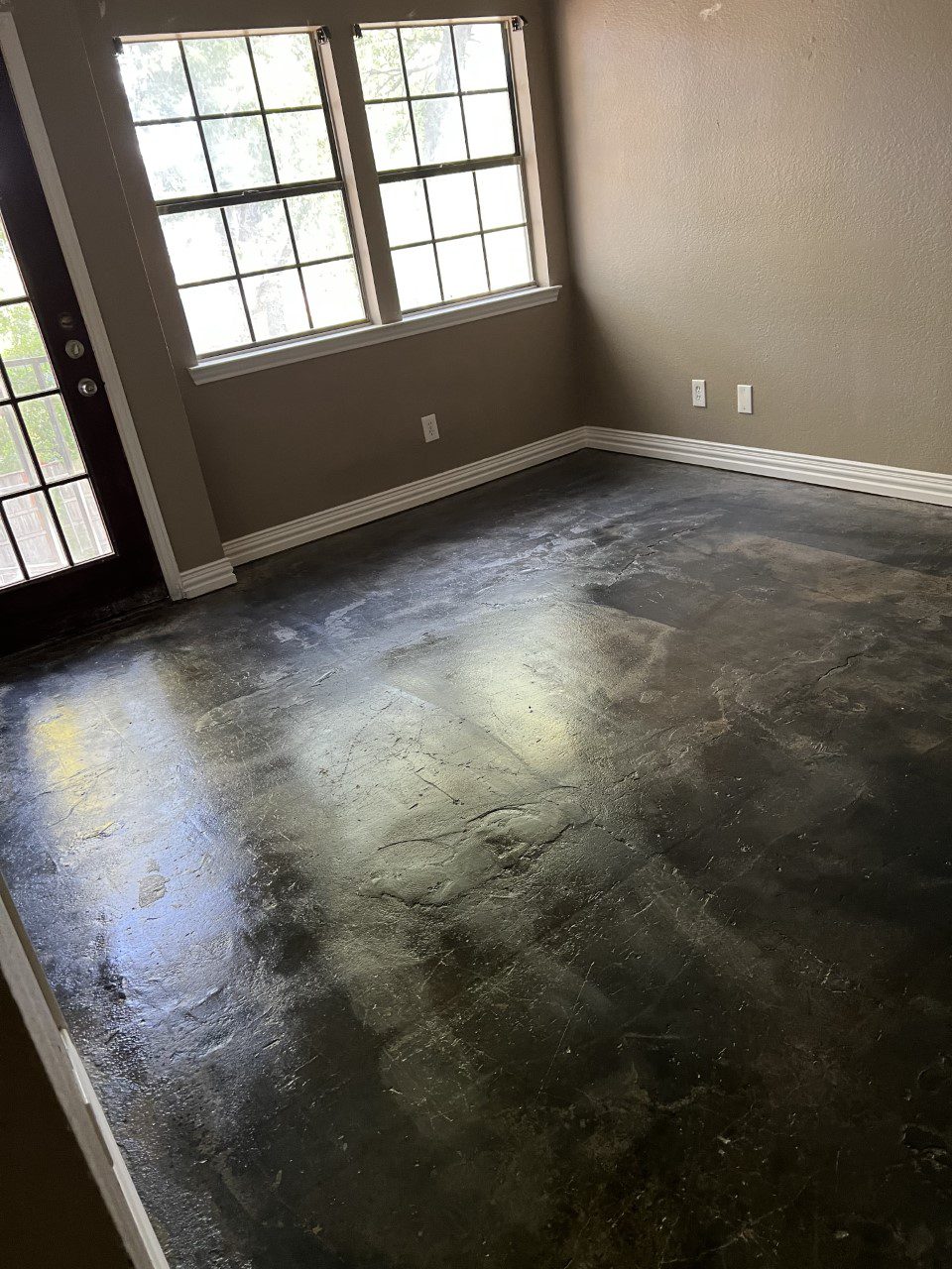 Black stained concrete floor beautifully transformed with black, stone gray, and iron gray ColorWave water-based concrete stains, showcasing a stunning and unique color blend.