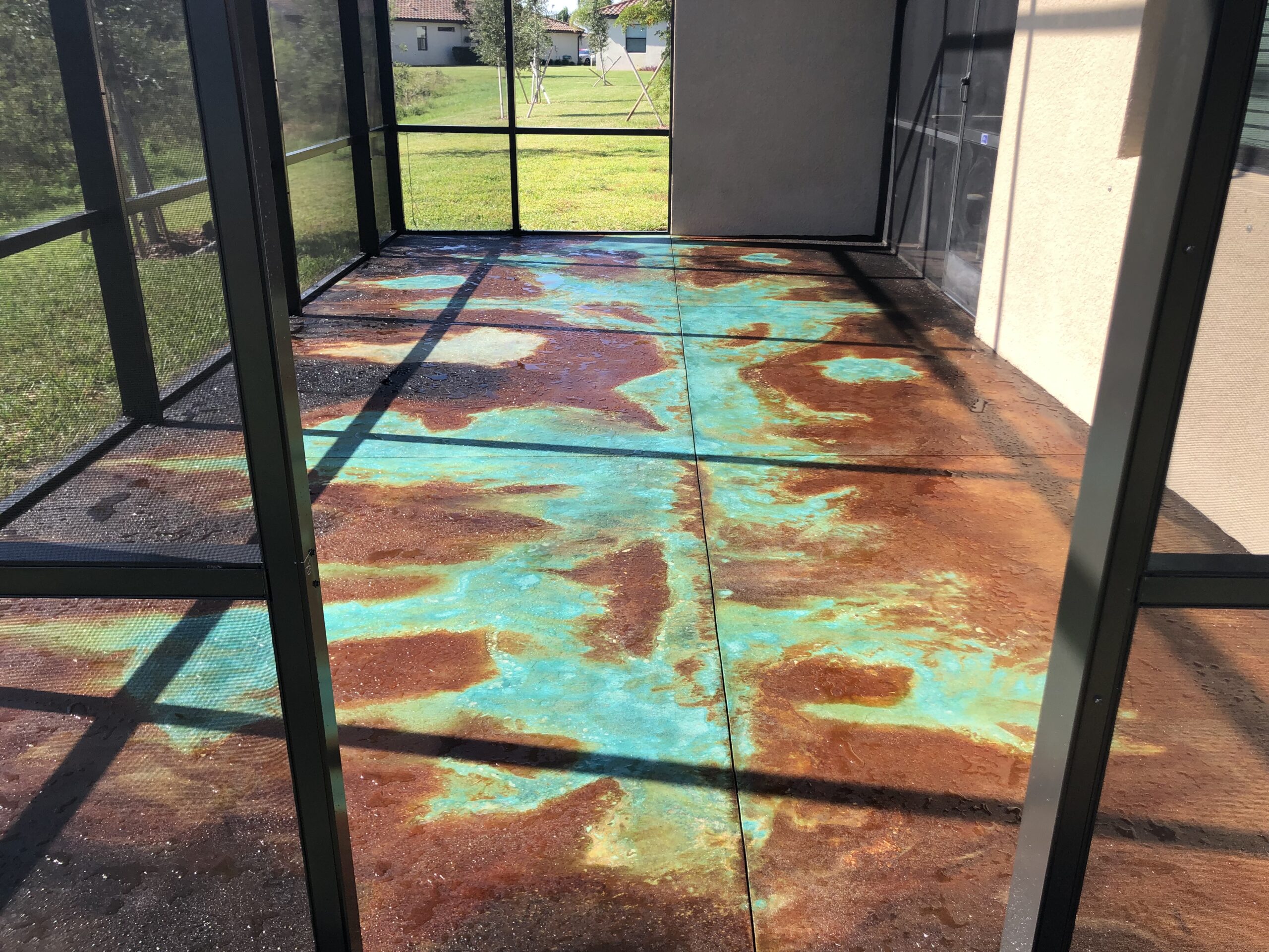 EEnclosed patio stained using the flowing water-color acid stain veining technique