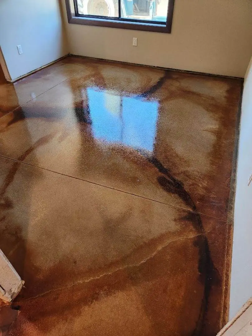 Concrete floor stained with a combination of EverStain Black, Desert Amber, and Malayan Buff acid stains using a freehand veining technique for a marbled effect.