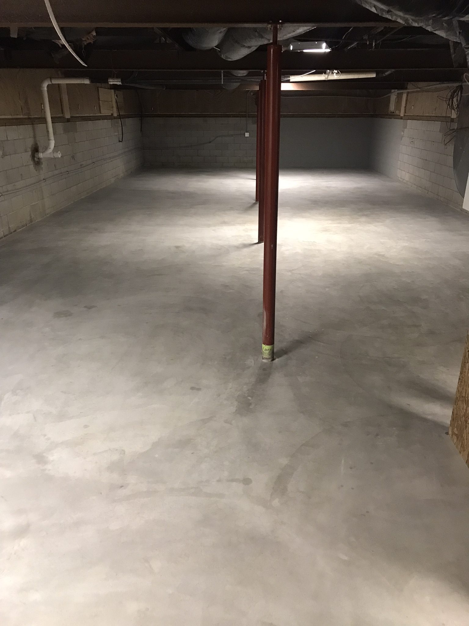 Bare basement space with plain walls and a raw concrete floor.