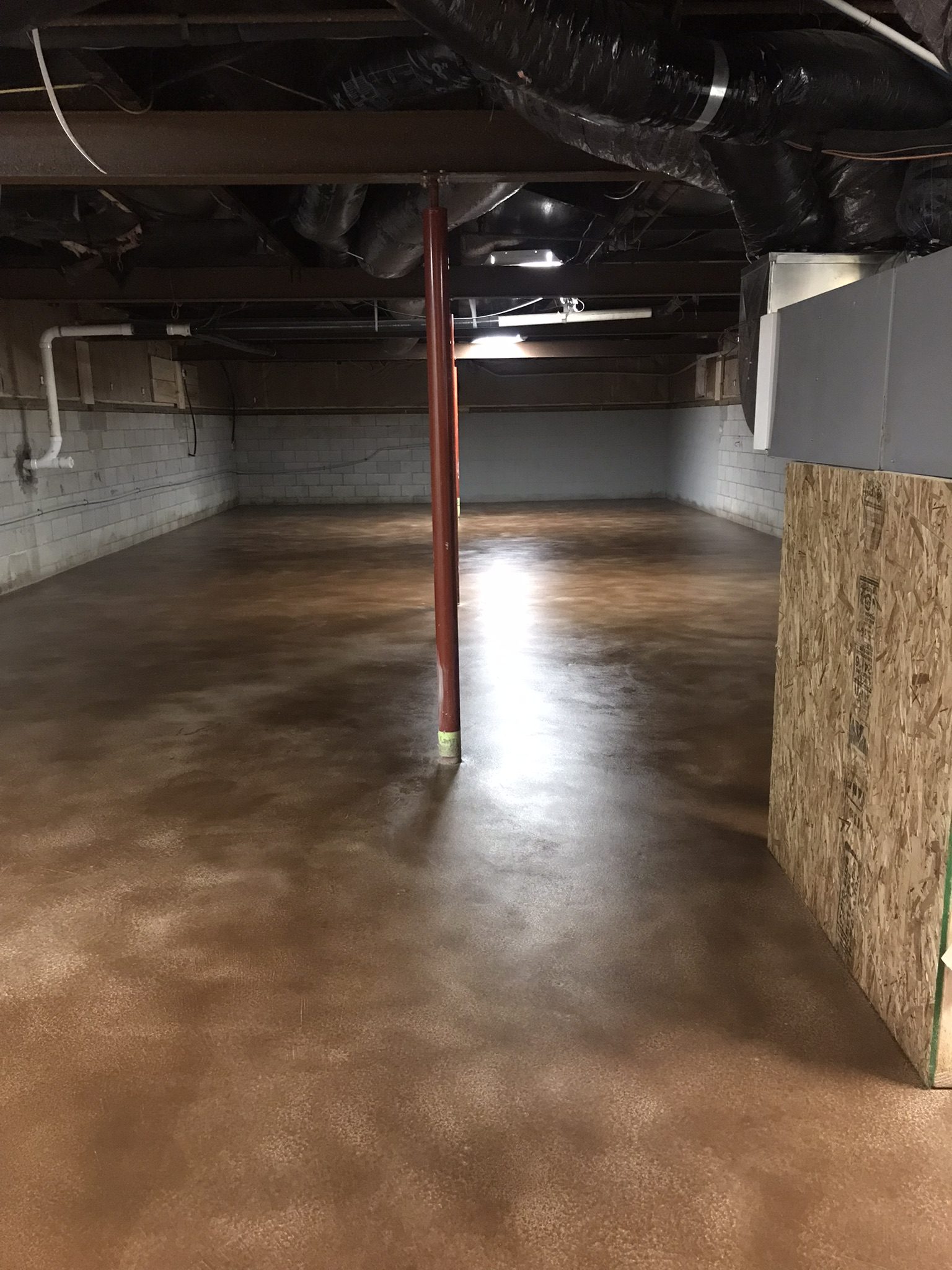 Cozy basement transformation with the floor stained in a warm Driftwood shade from AcquaTint™, complemented by a subtle satin sheen from ProWax Polish™