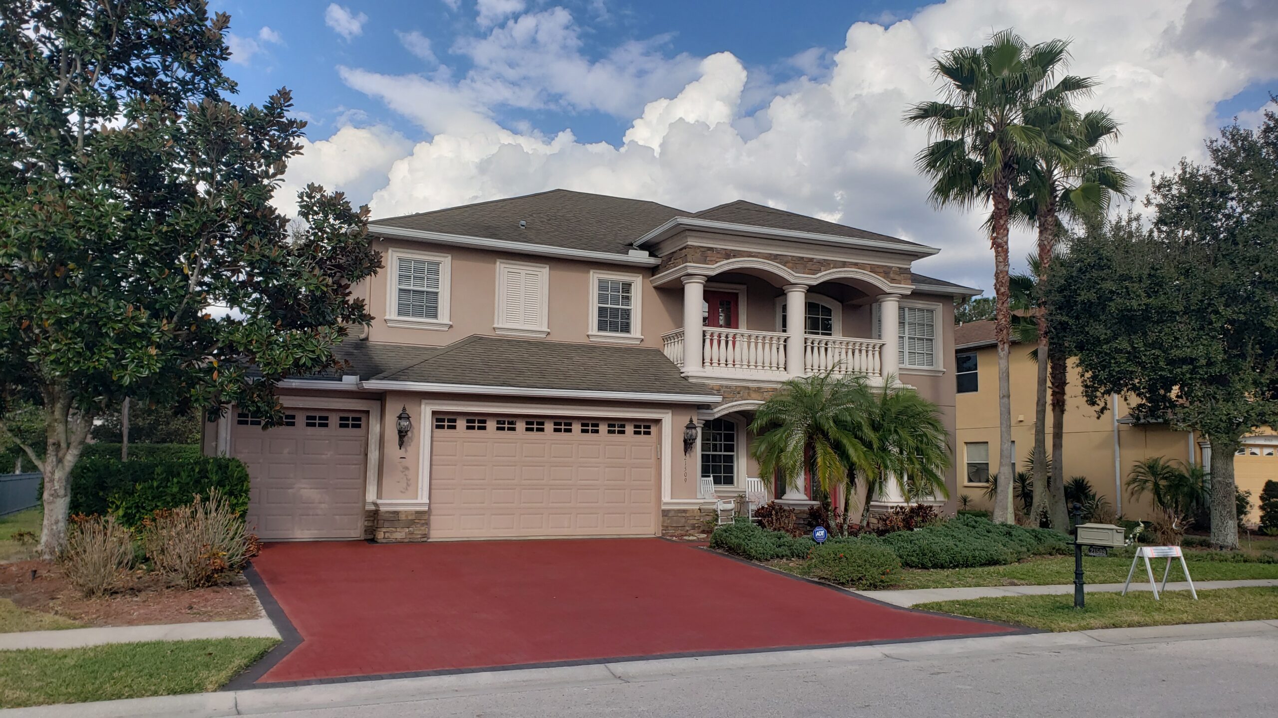 Milano Red EasyTint stained brick paver driveway with a sleek charcoal edge design