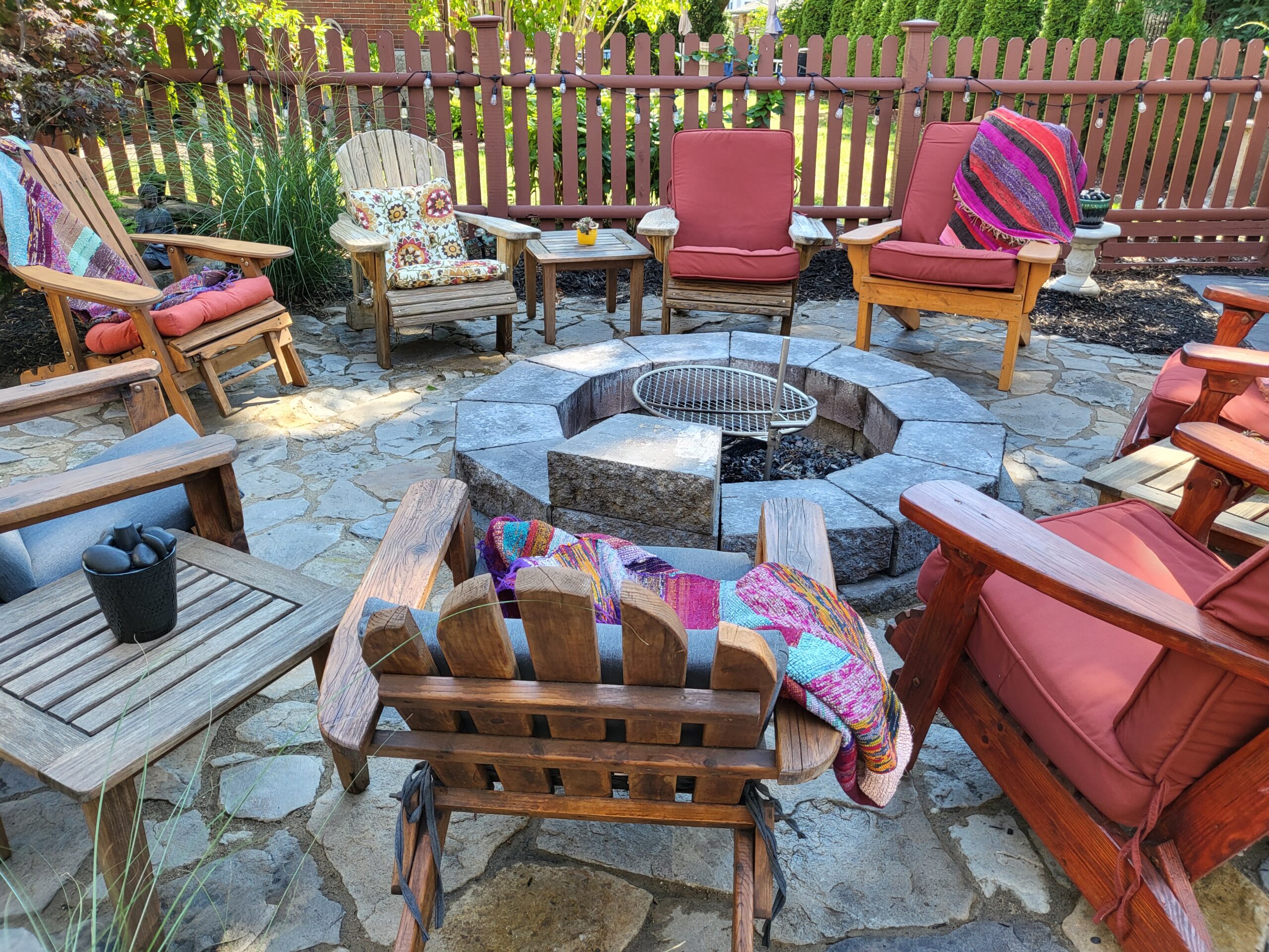 A DIY patio design showcasing an inviting fire pit, surrounded by multicolored stones stained to resemble slate, creating a warm and welcoming outdoor space.