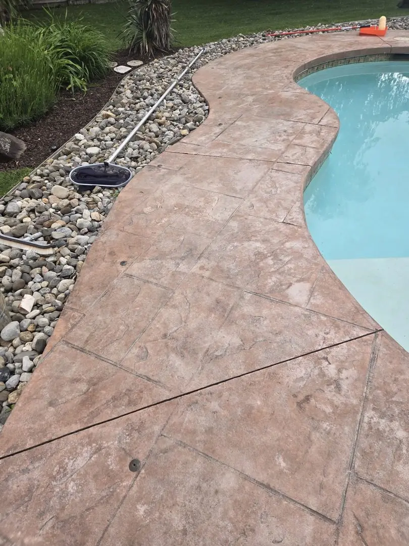 A faded stamped concrete pool deck before restoration with Cumin EasyTint.