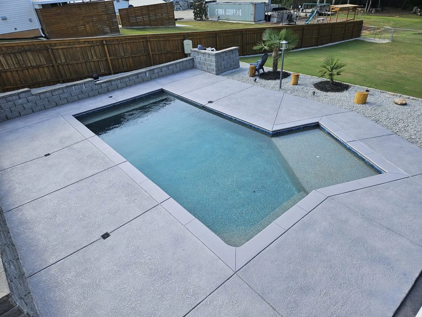 A modern pool with a stamped concrete deck in Eagle Gray, featuring a smooth and sleek finish.