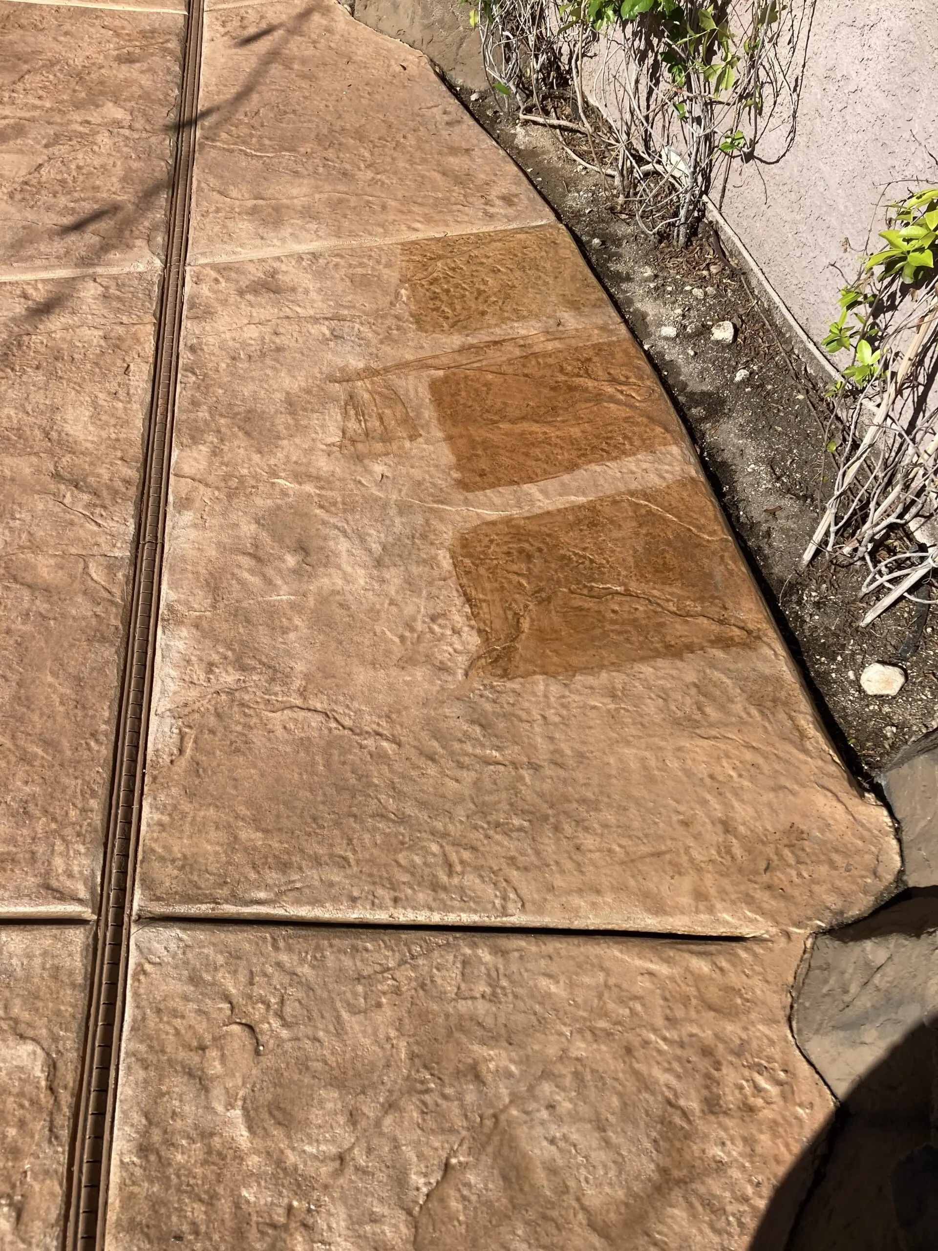 Three test patches of Antiquing stain colors (Yukon Gold, Café Royale, and Goldenrod) on a faded stamped concrete pool deck.