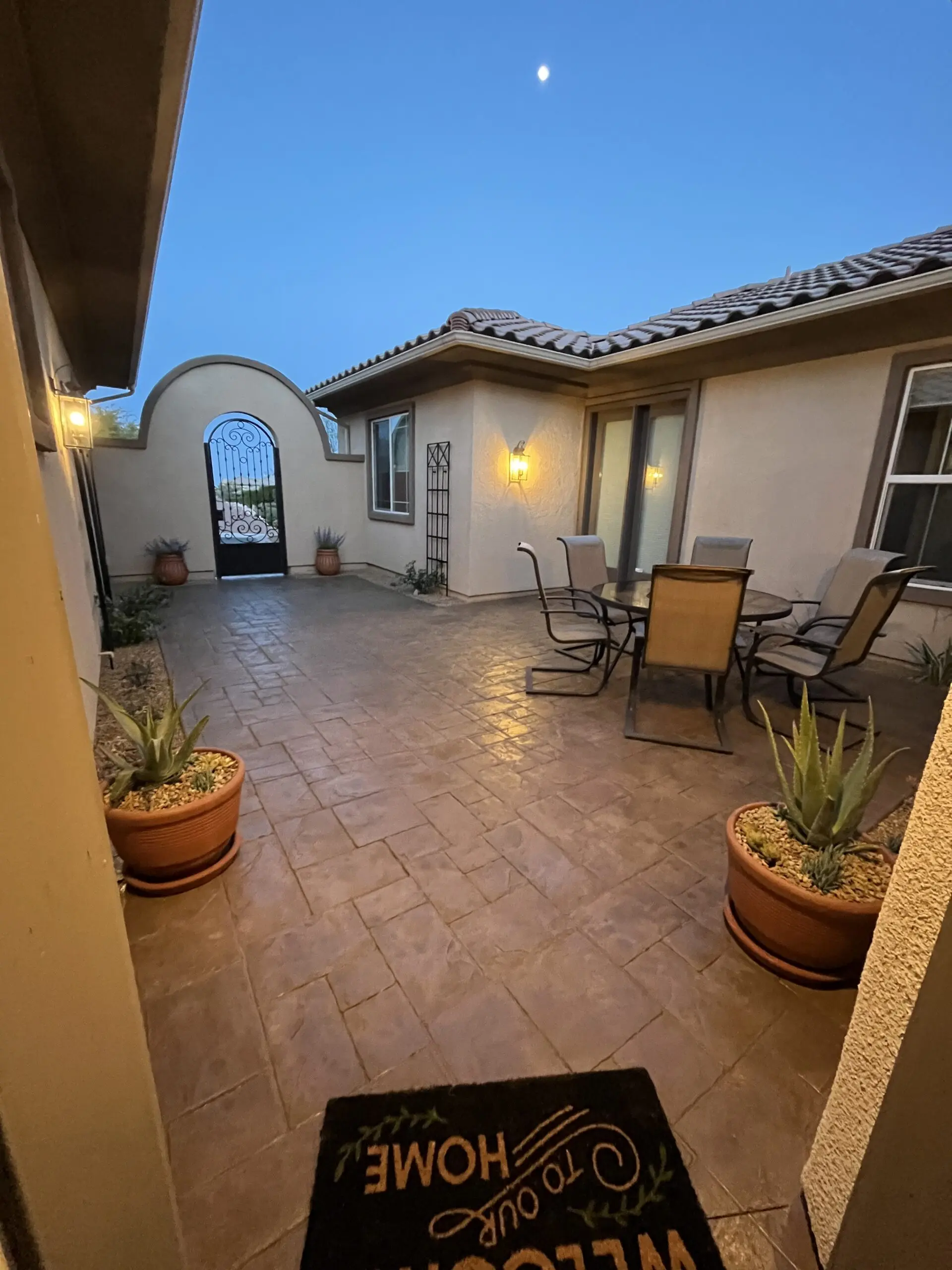 rejuvenated courtyard showcasing a rich tweed color from the staining, exhibiting a beautiful contrast against the newly planted greenery.