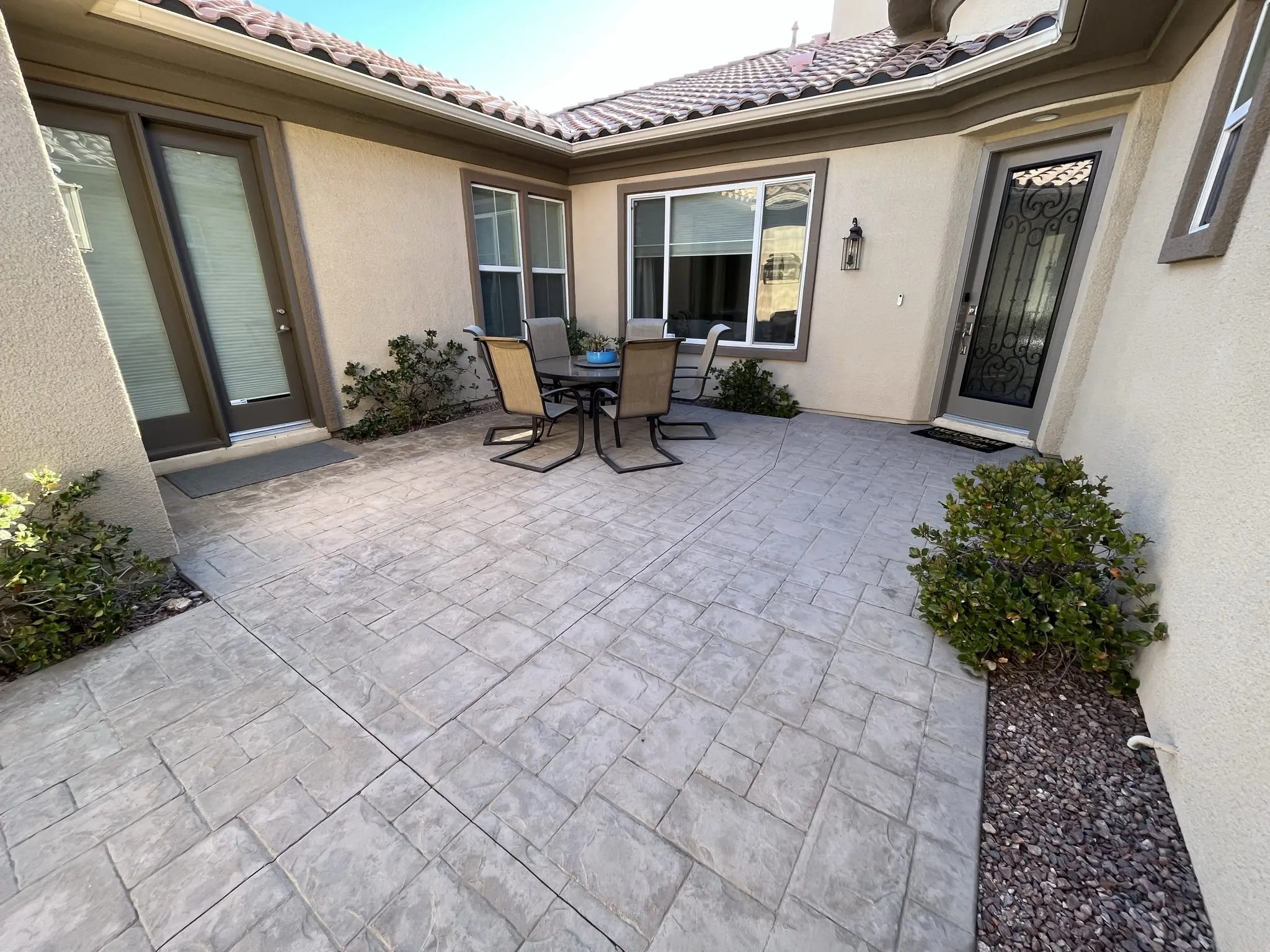 A faded stamped concrete courtyard prior to staining