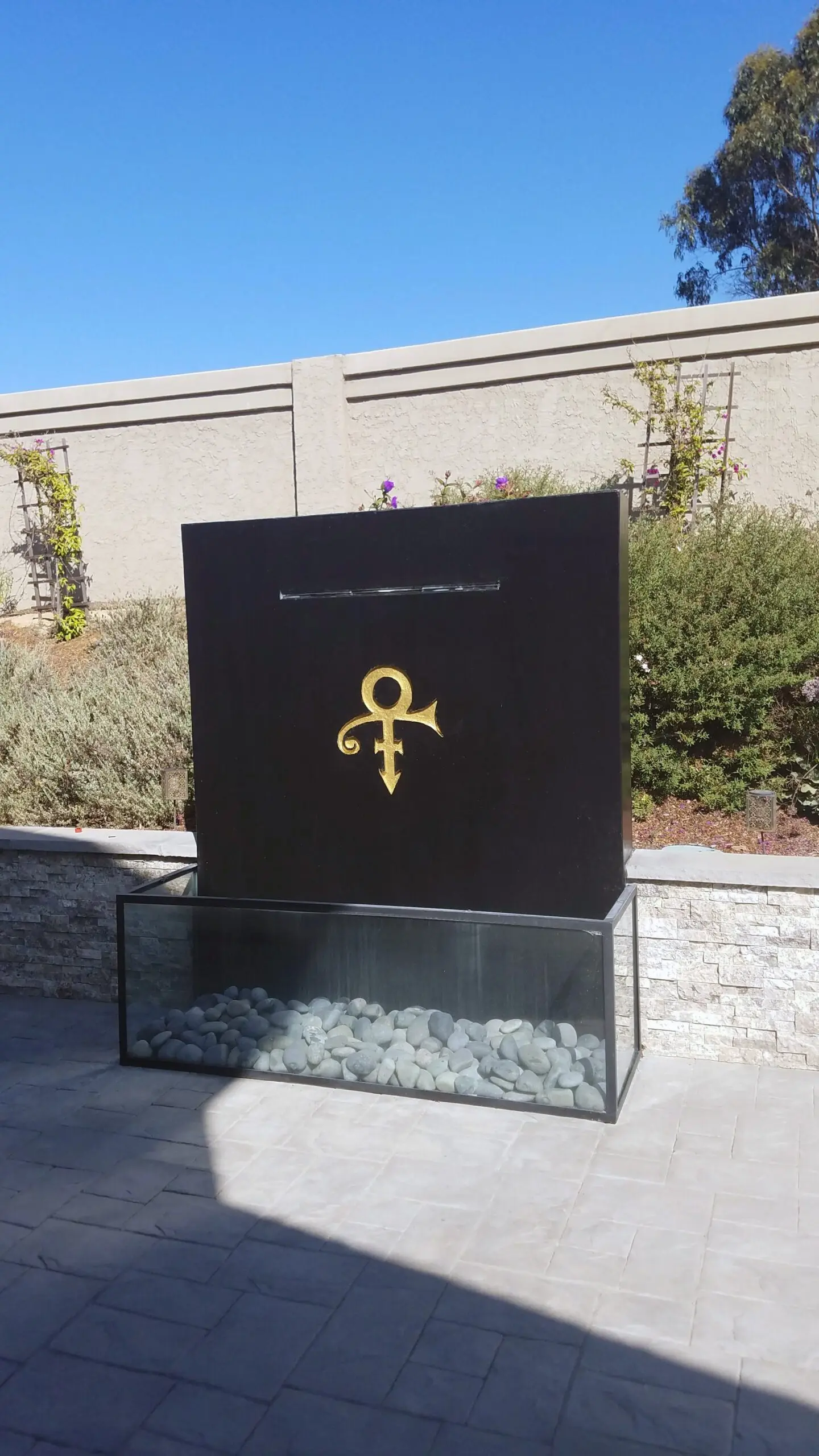 After image displaying a refreshed concrete monument to Prince, restained with black ColorWave and featuring the Prince sign engraved in gold.