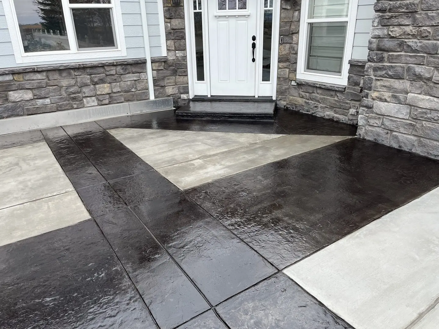Image showcasing a scored concrete front porch stained with black EasyTint tinted sealer in a high gloss finish.