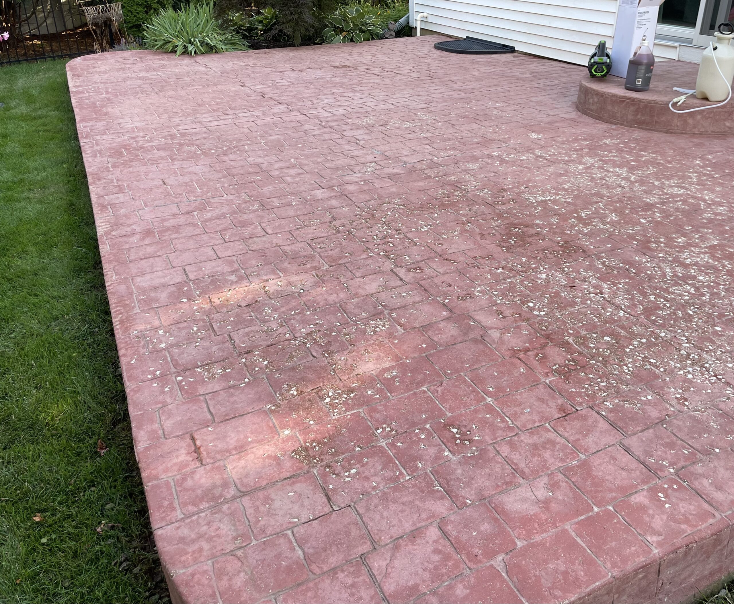 A neglected stamped concrete surface, showing signs of discoloration and wear, turned into an unappealing chalky pink color Before: Our stamped concrete had turned an unappealing chalky pink
