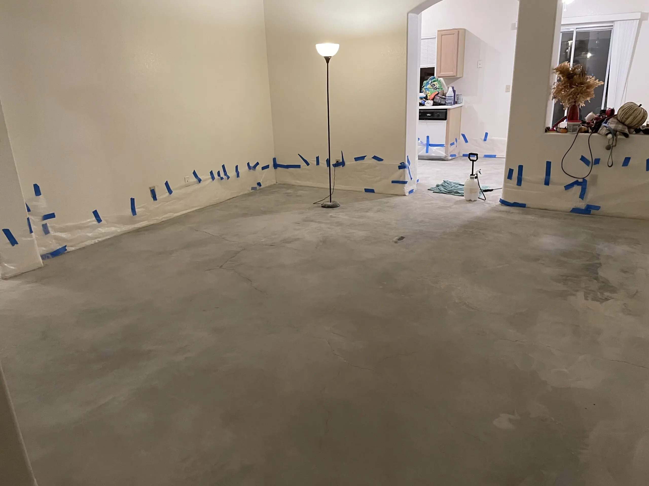 An image of a living room with bare, cleaned concrete floors, ready for the staining process.