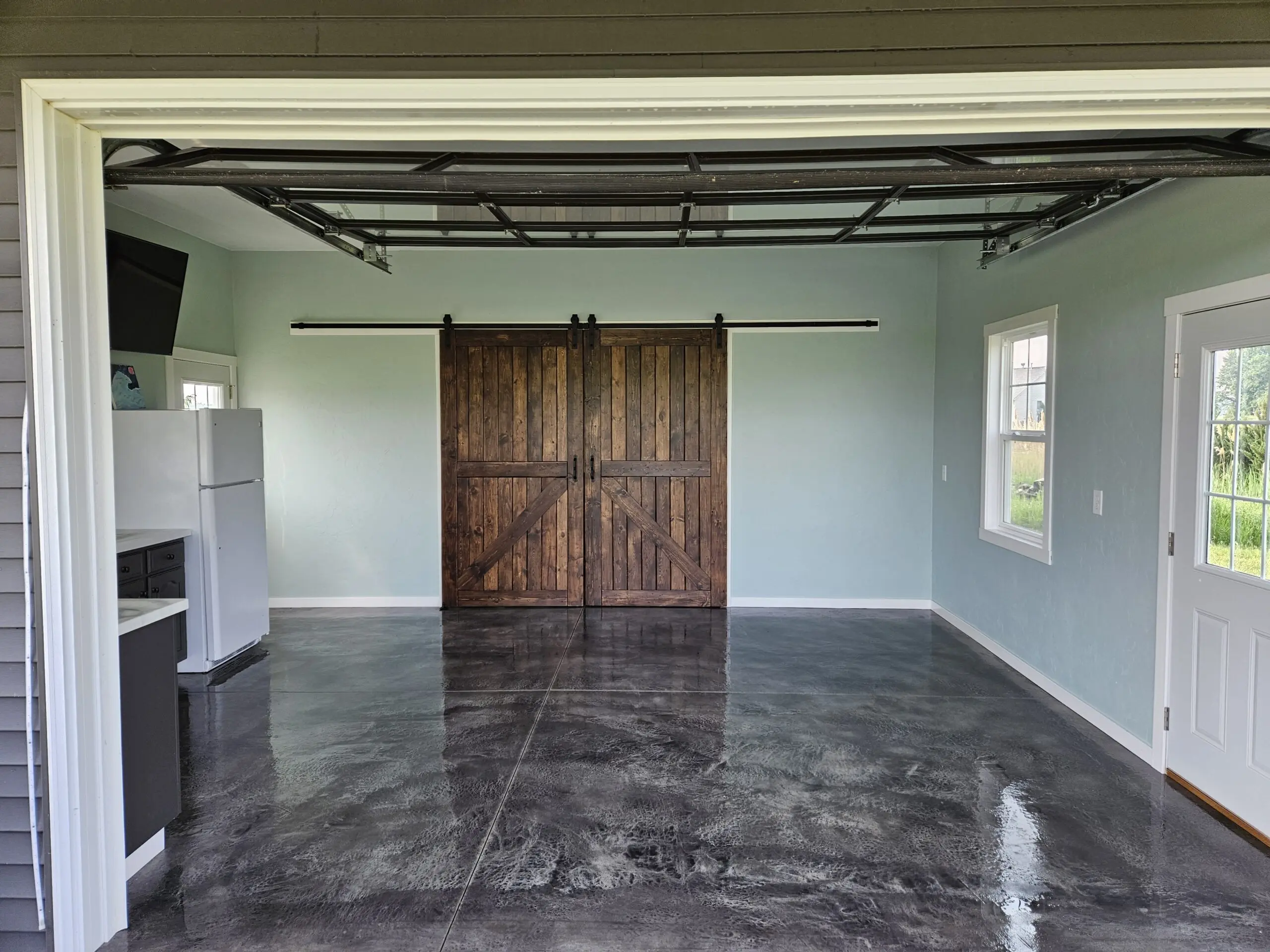 Finished garage showcasing the beautiful, textured and stained concrete floor