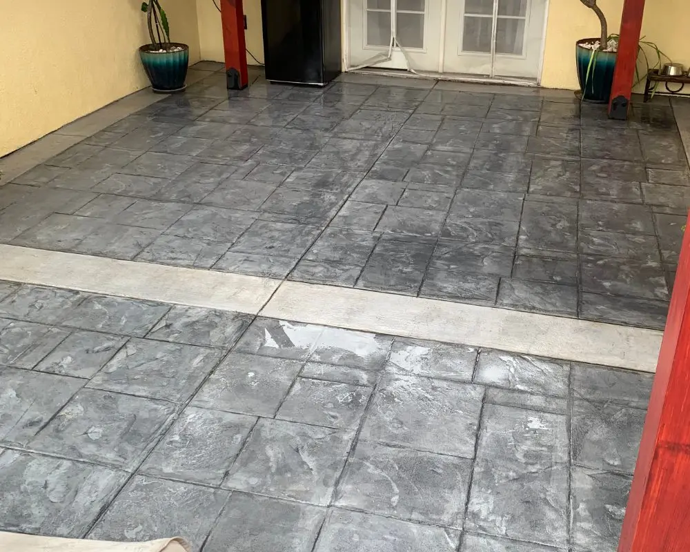 Worn-out stamped concrete courtyard before the application of stain and sealer
