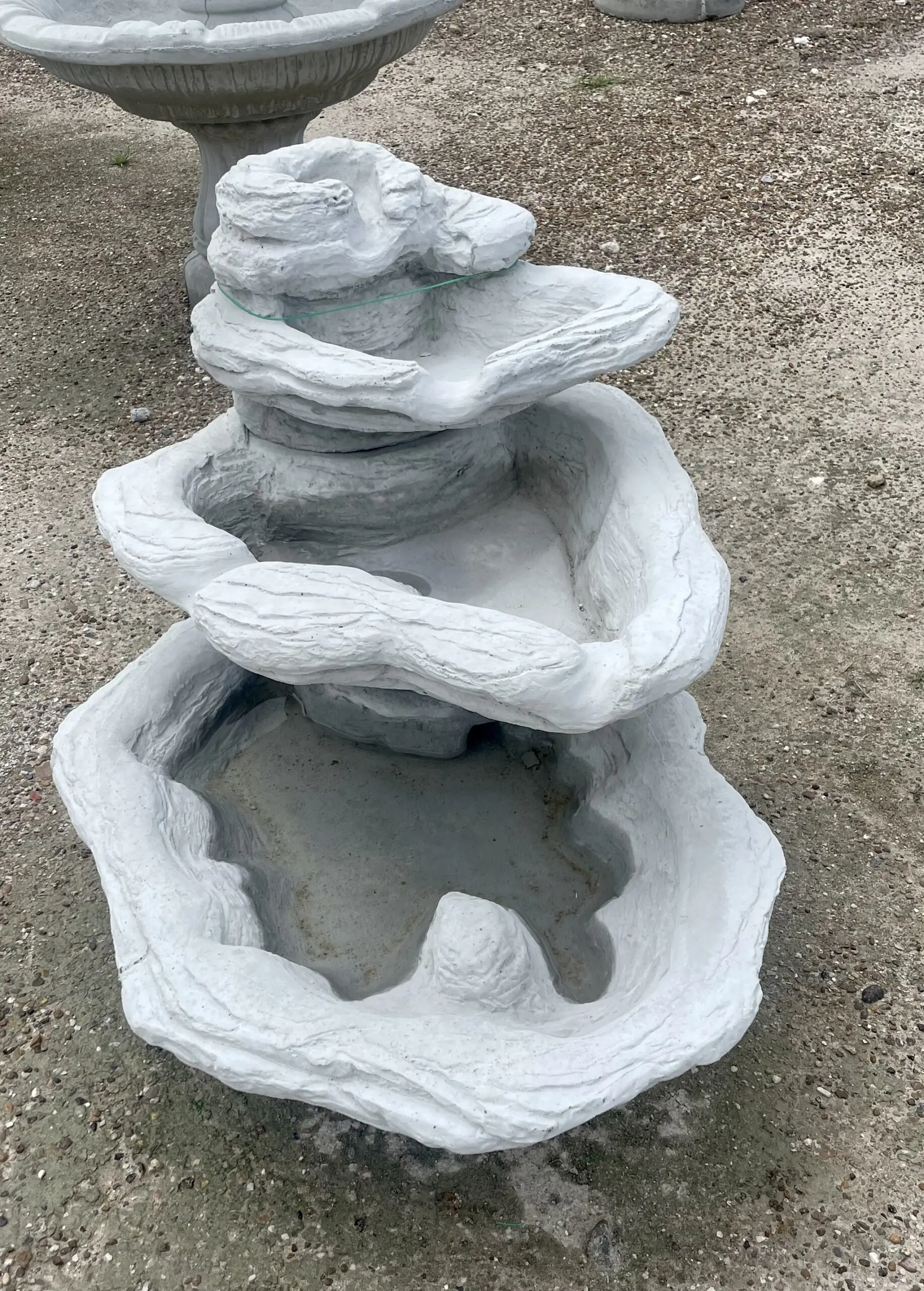 A photo of a bare concrete succulent "fountain" on a patio, before staining