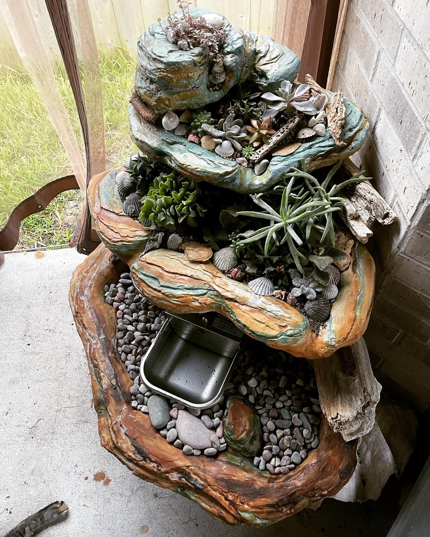 A photo of the succulent "fountain" on the patio, vibrantly stained in Azure Blue, Desert Amber, and English Red