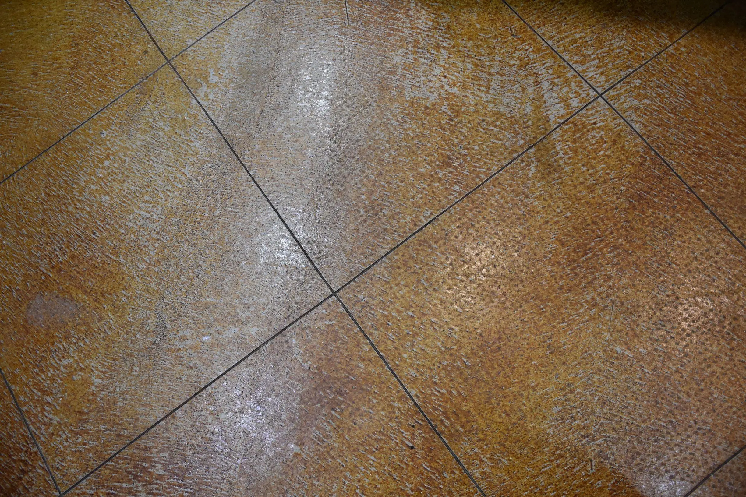 Faded concrete floor with a worn finish before applying stain