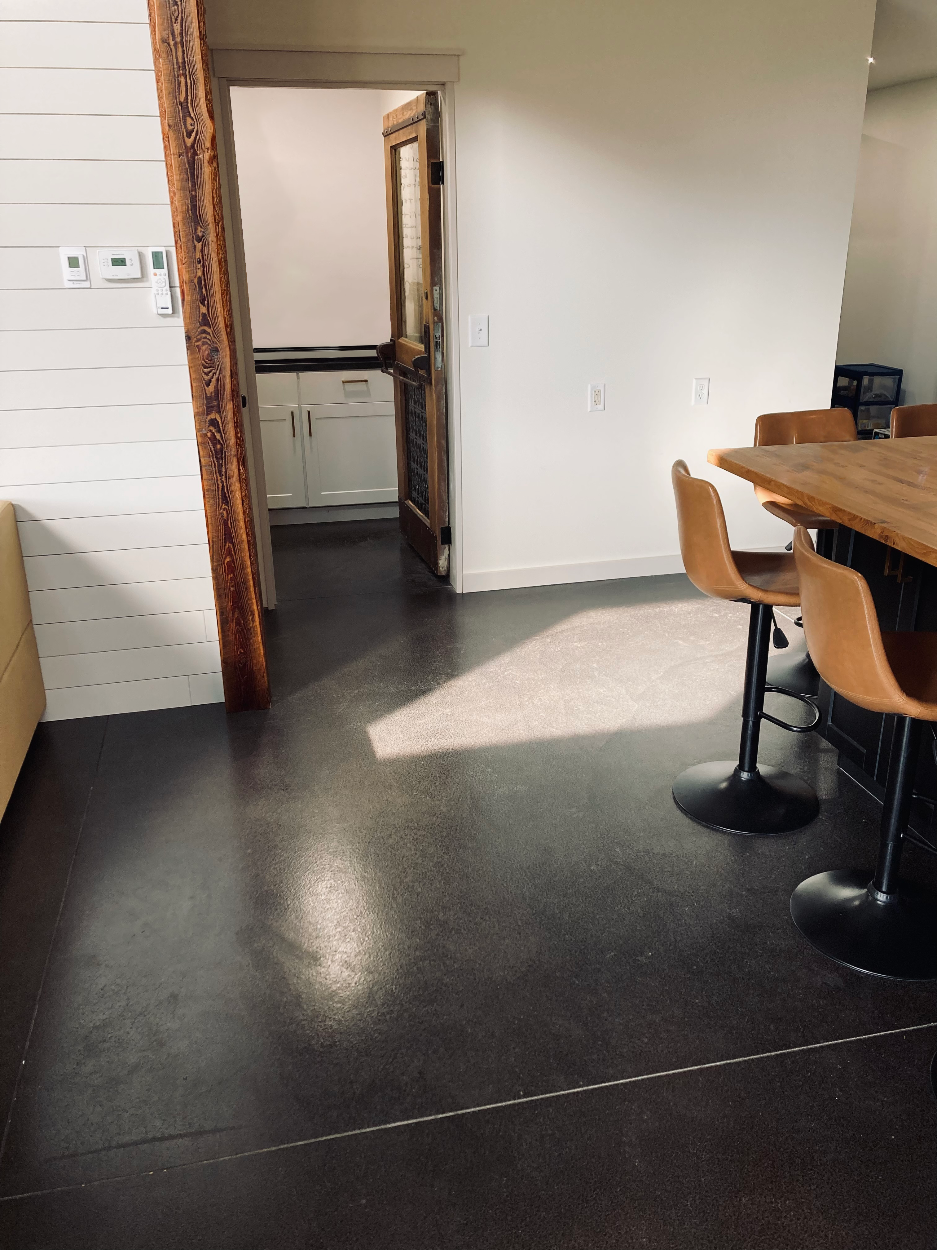 Sleek and polished living area floor, beautifully stained with AcquaTint™ Black and finished with ProWax Polish™, reflecting the ambient lighting.