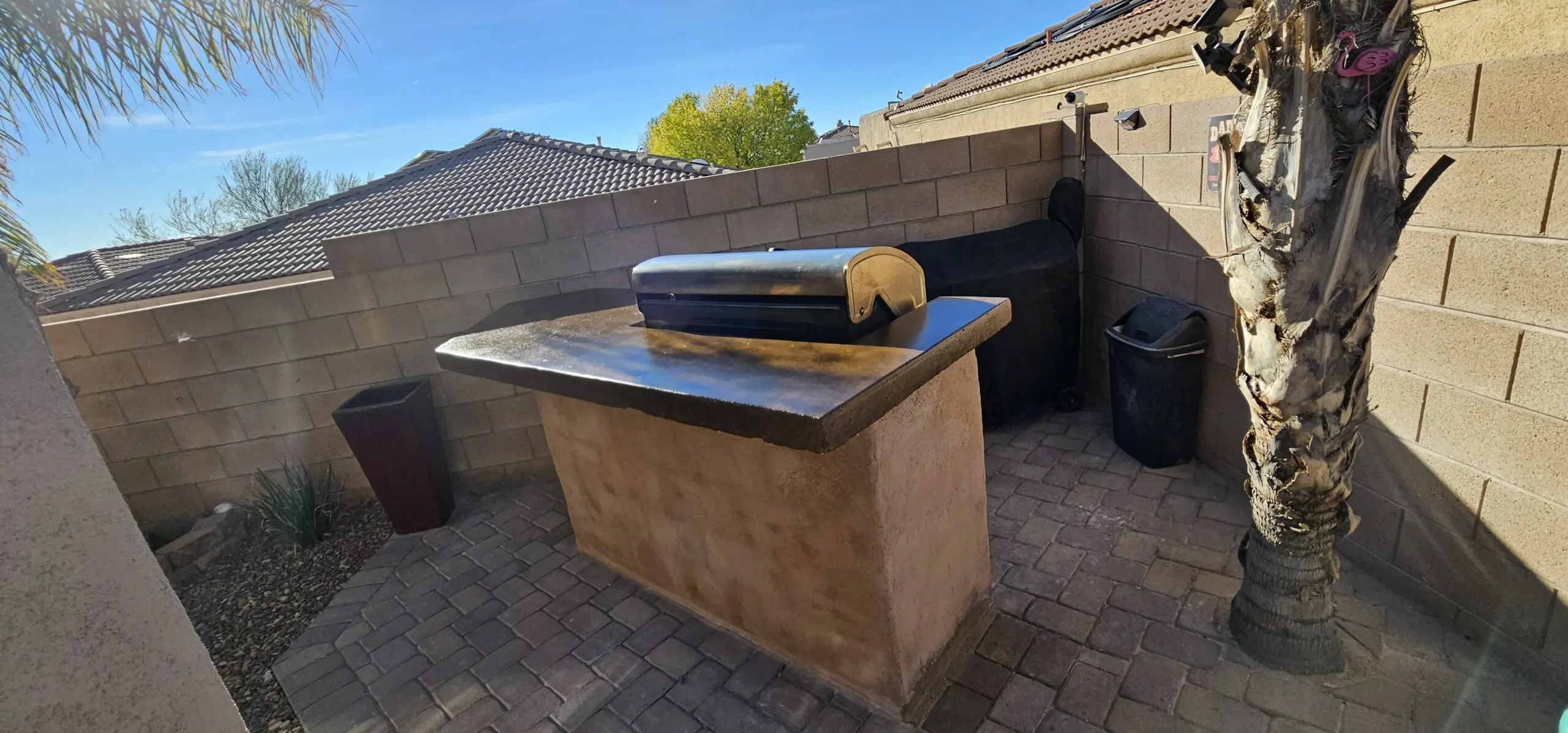 Image of an outdoor grill countertop after restoration, featuring a glossy, marbled finish achieved using Cumin and Aztec brown stains.