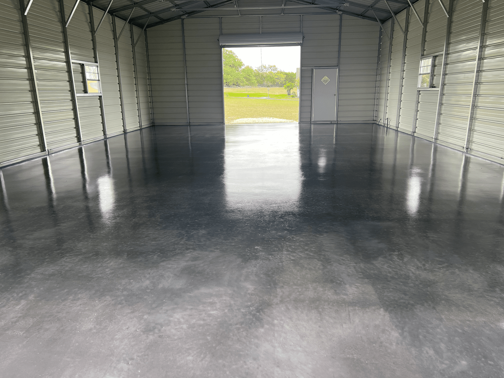 Steel garage floor transformed with a sleek charcoal finish, gleaming in its satin perfection.