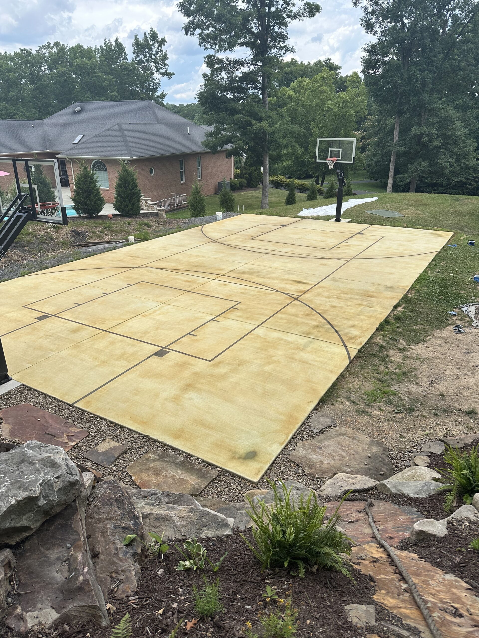 A wide view of the basketball court with the EverStain Avocado acid stain processing, showing a vibrant greenish hue