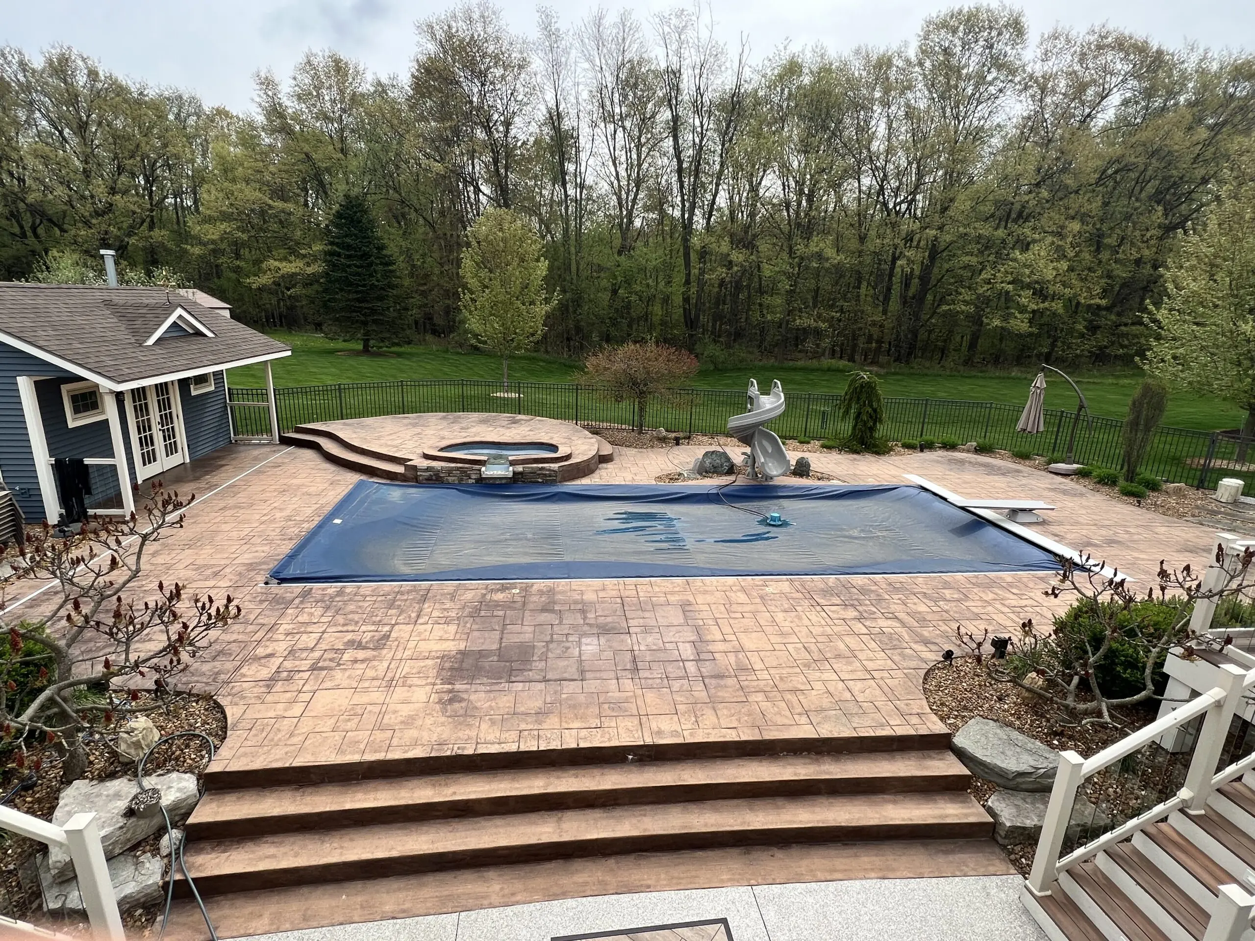 Weathered pool patio with darker spots under rugs and furniture