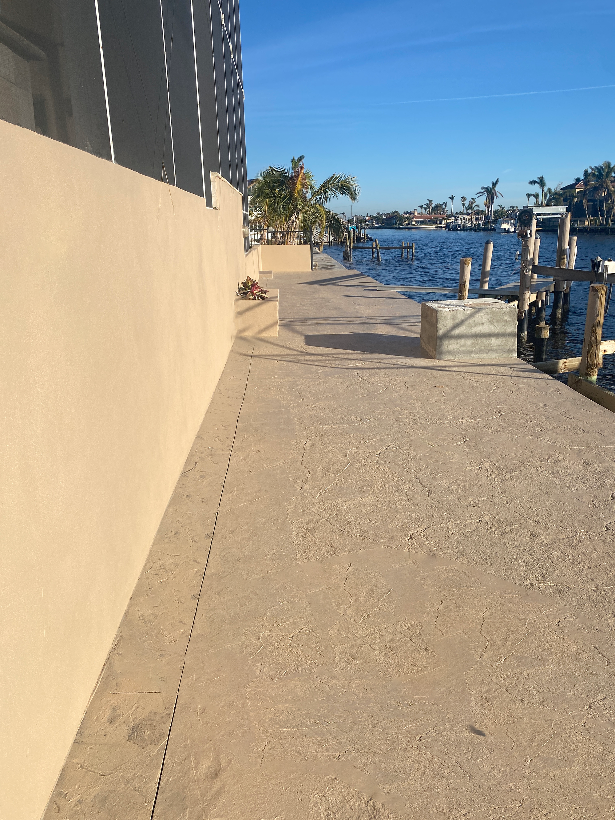 A beautifully sealed stamped concrete dock covering showcasing the tan hues of EasyTint™ against the surrounding waters