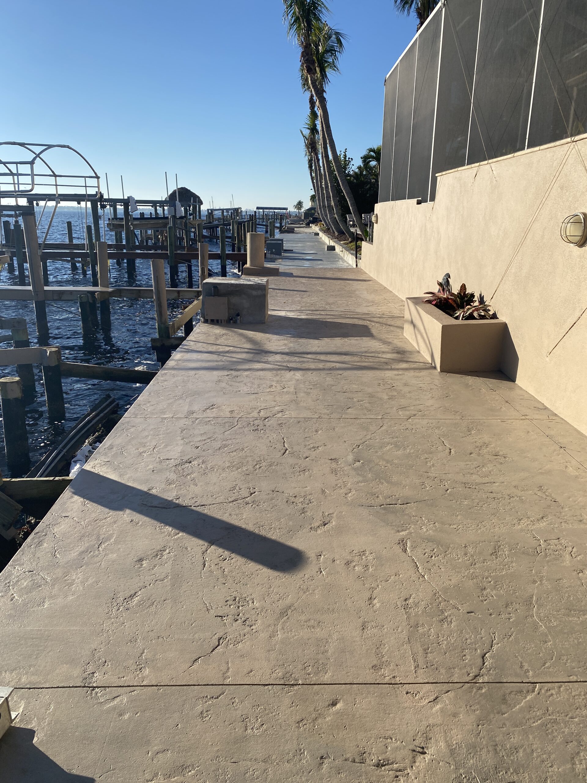 Finished stamped concrete dock, glistening under sunlight, treated with EasyTint™ Tan Tinted Sealer.
