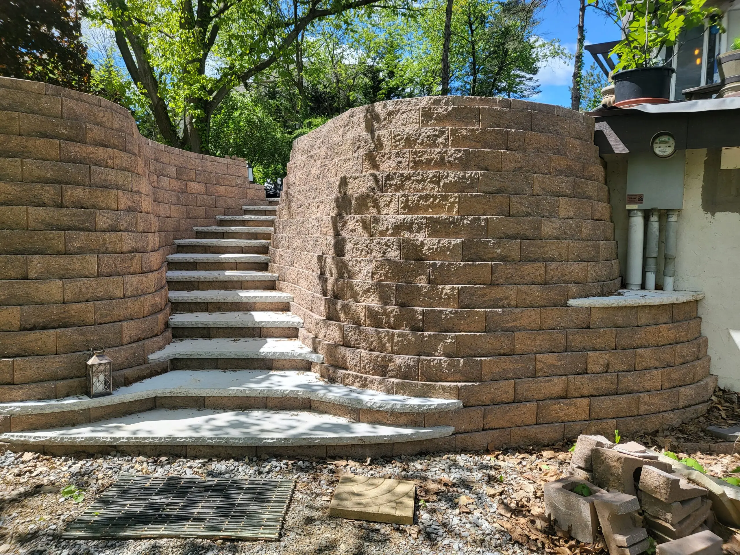 Unfinished retaining wall and steps leading to the patio extension, prior to staining
