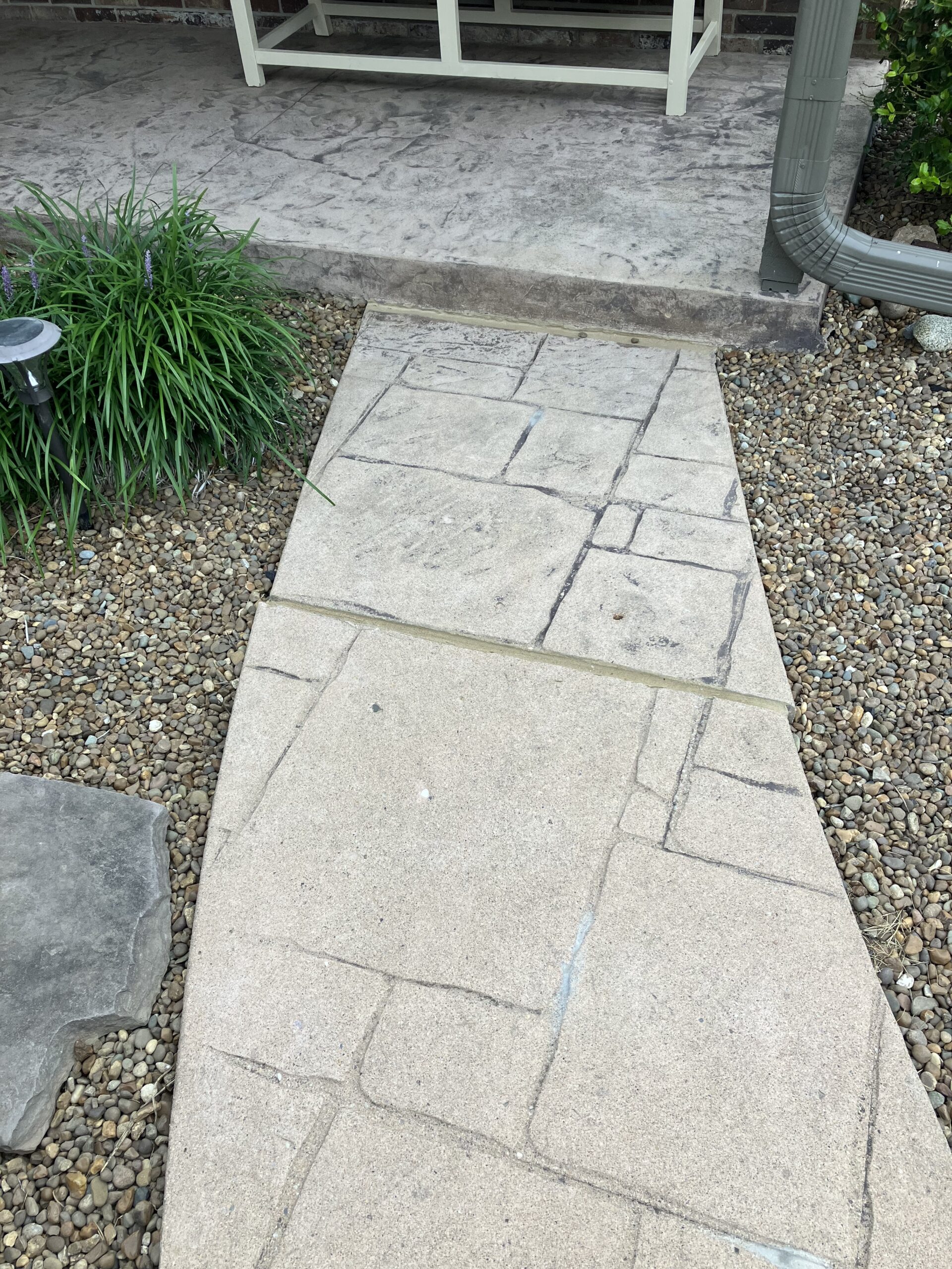 Unstained, faded stamped concrete sidewalk before restoration
