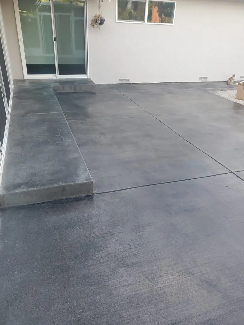Alternate angle of the finished back patio, highlighting the refined black-stained concrete