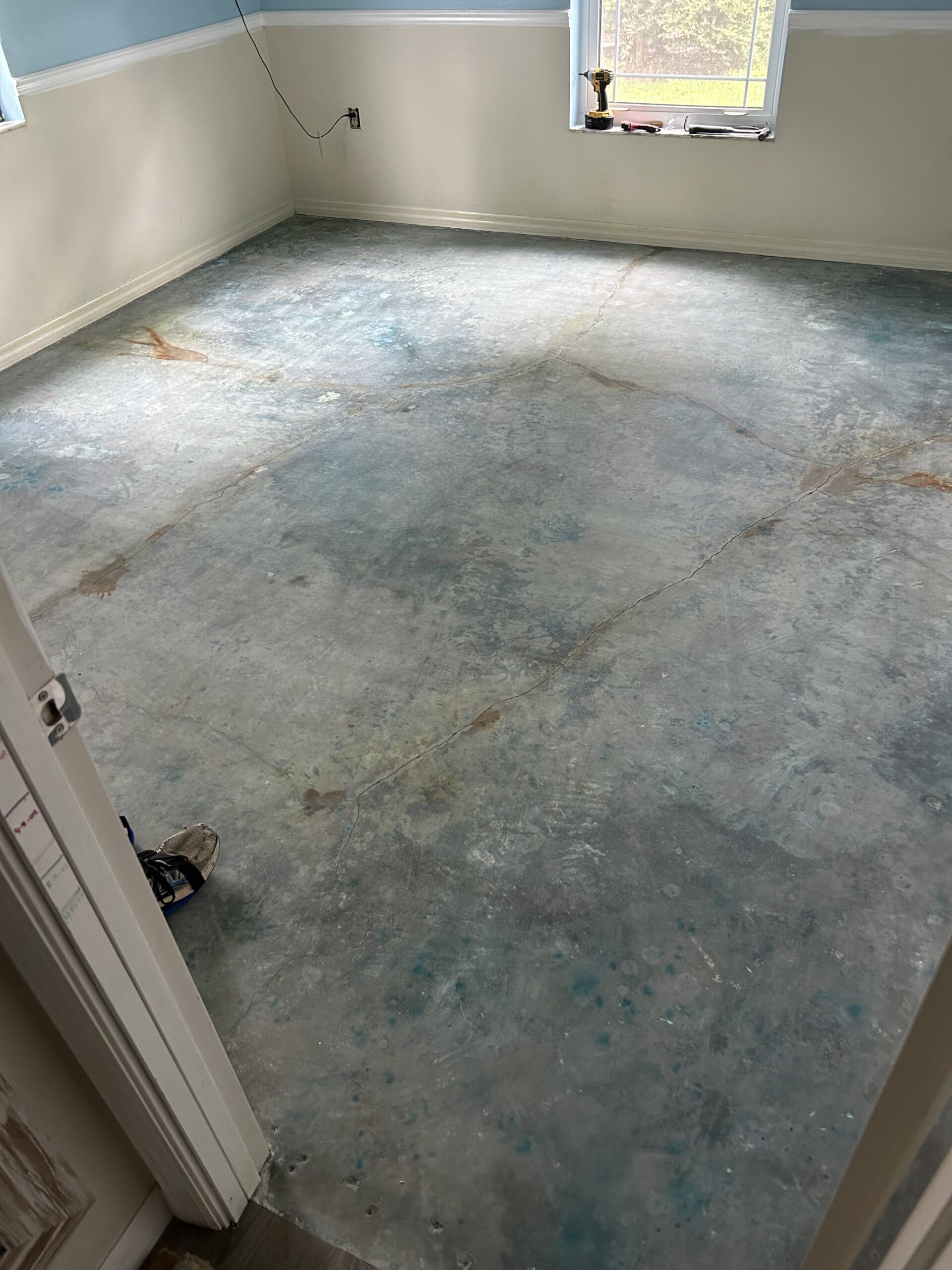 Concrete floor cleaned, neutralized, and dried after acid staining, showing the preparation before sealing