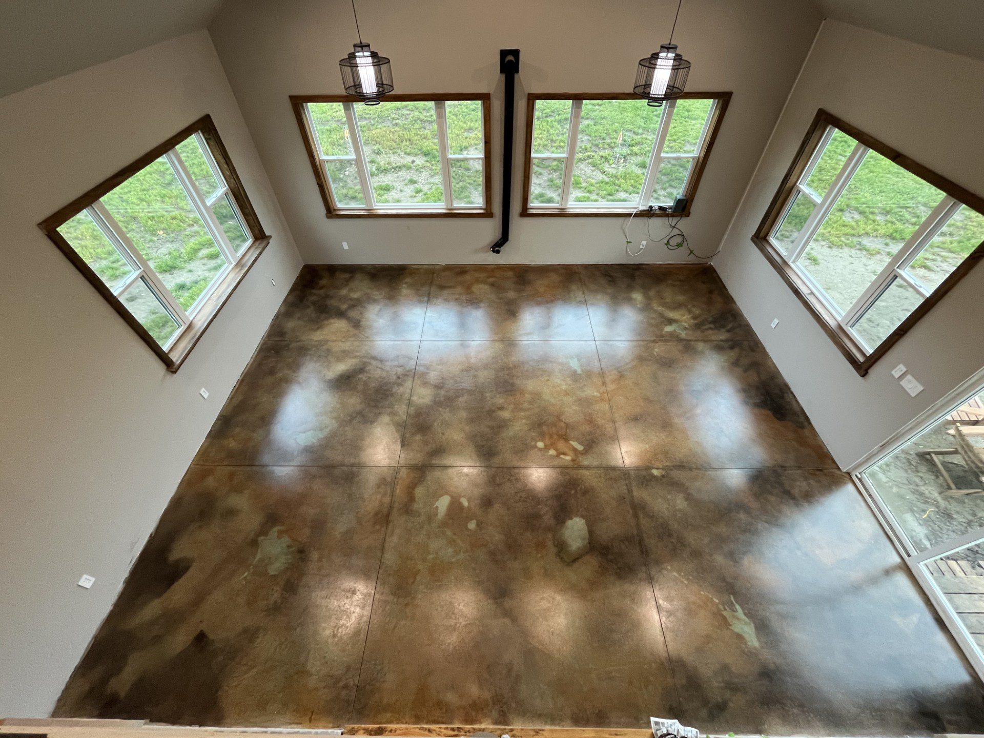 Acid-stained concrete floor with rich layers of brown, green, and black hues.