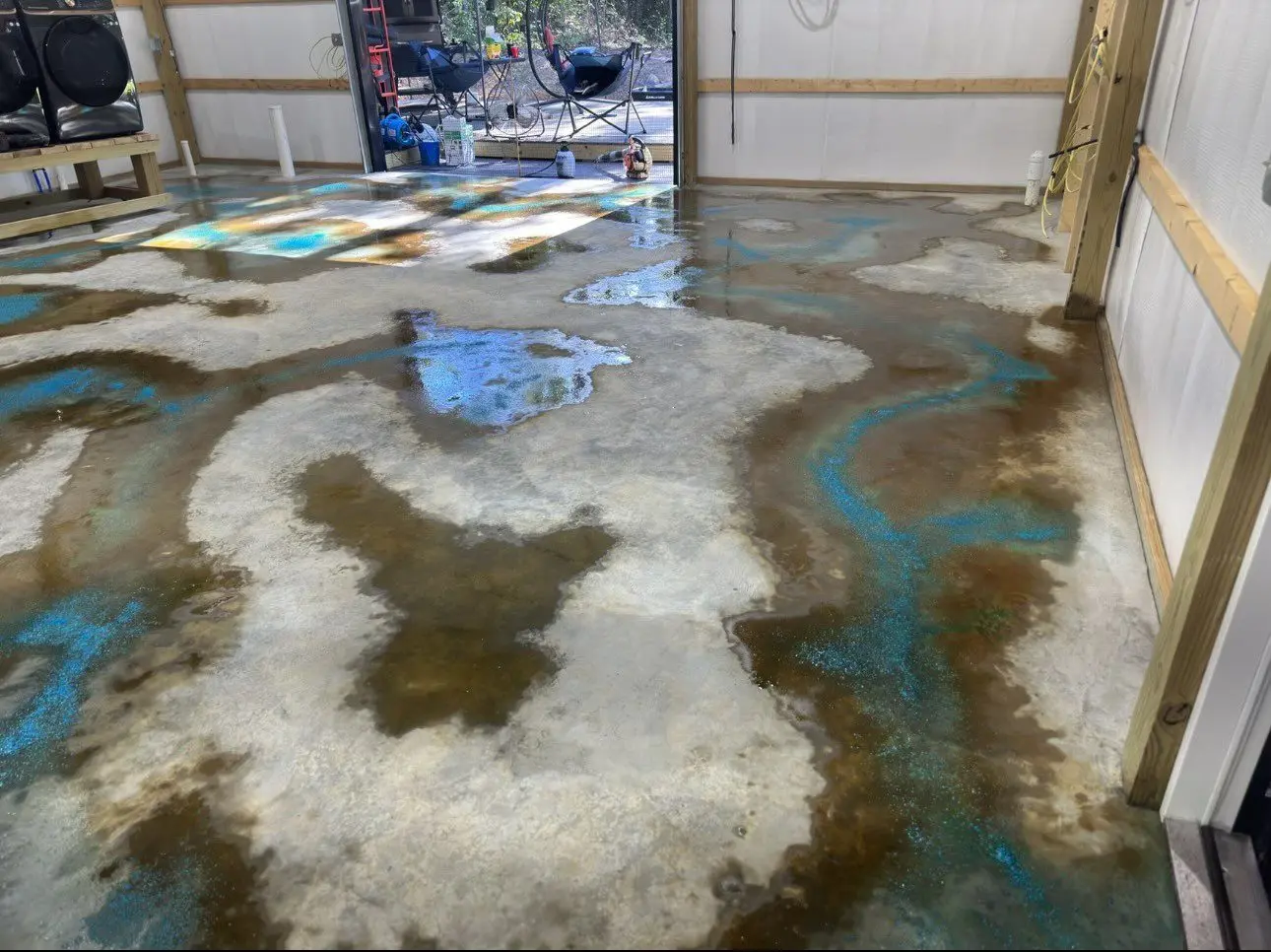 Concrete floor with Miracle Gro granules applied in a vein-like pattern, stained with Azure Blue over the granules and English Red around them.