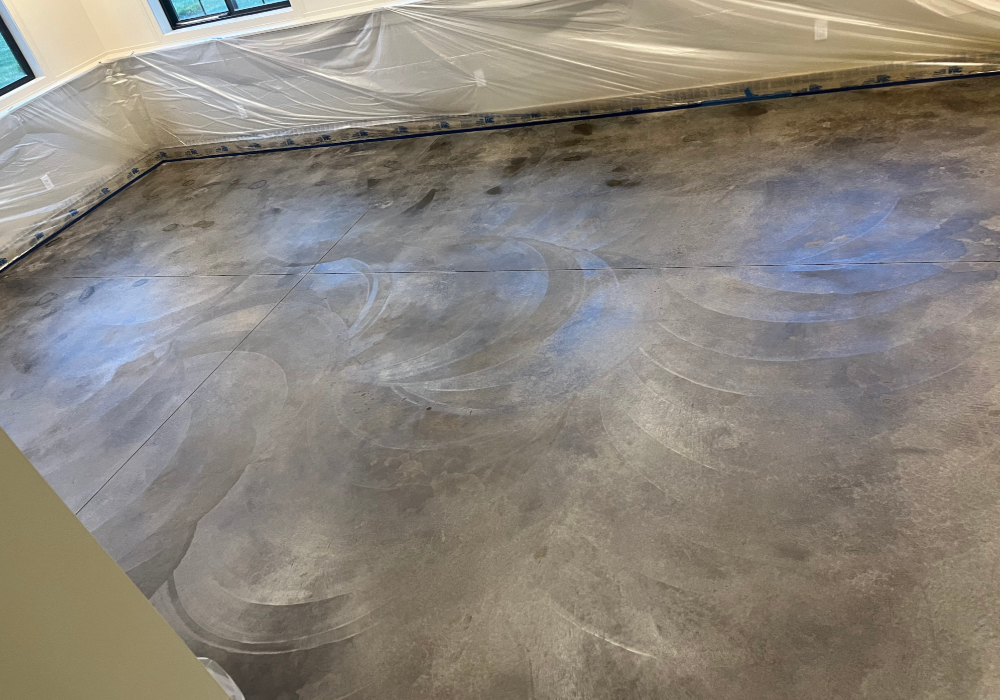 Concrete floor with Molasses stain applied, showing swirls and variations