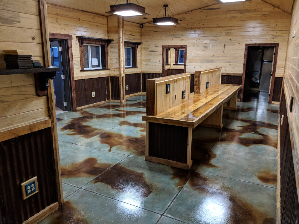 A barndominium office space with a concrete floor stained in a marbled pattern using azure blue and coffee brown acid stains