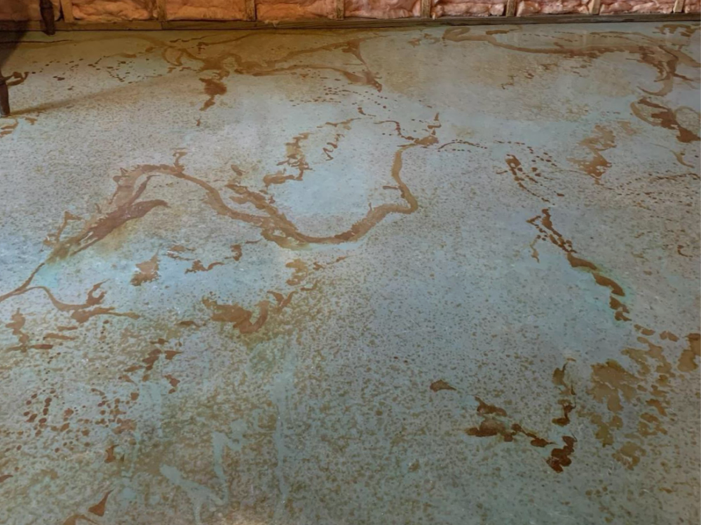 Detailed close-up of a concrete floor showing an intricate pattern with Azure Blue, English Red, and Malayan Buff acid stains creating a complex, earth-toned marbling effect.