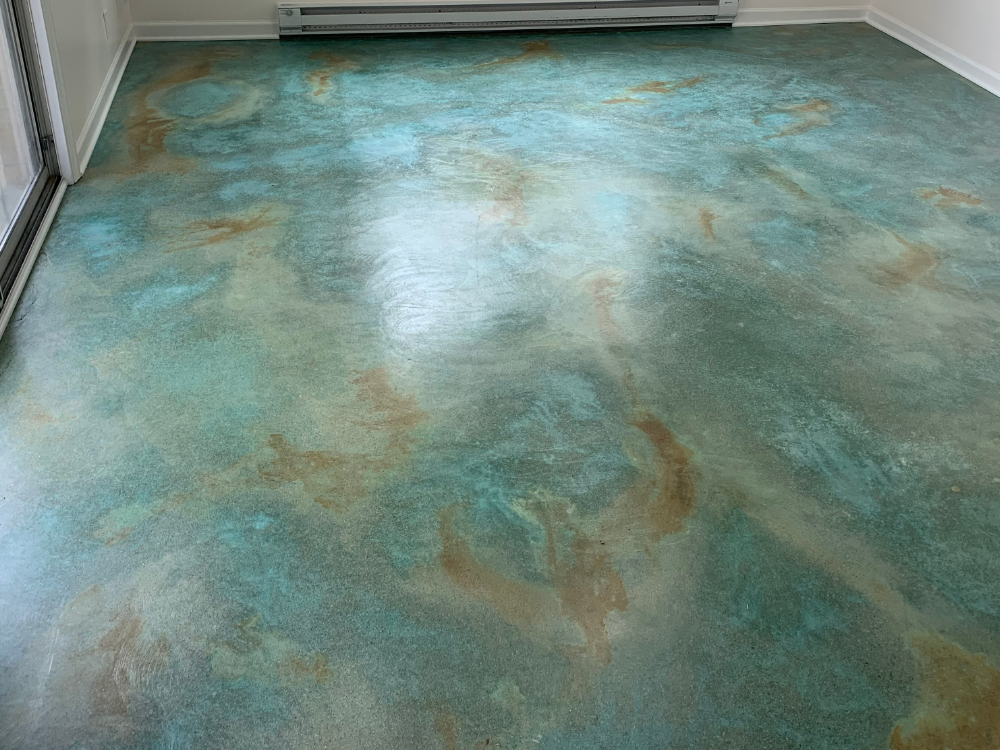 A sunroom floor acid-stained with EverStain Azure Blue and Shifting Sand, creating a marbled, ocean-like effect