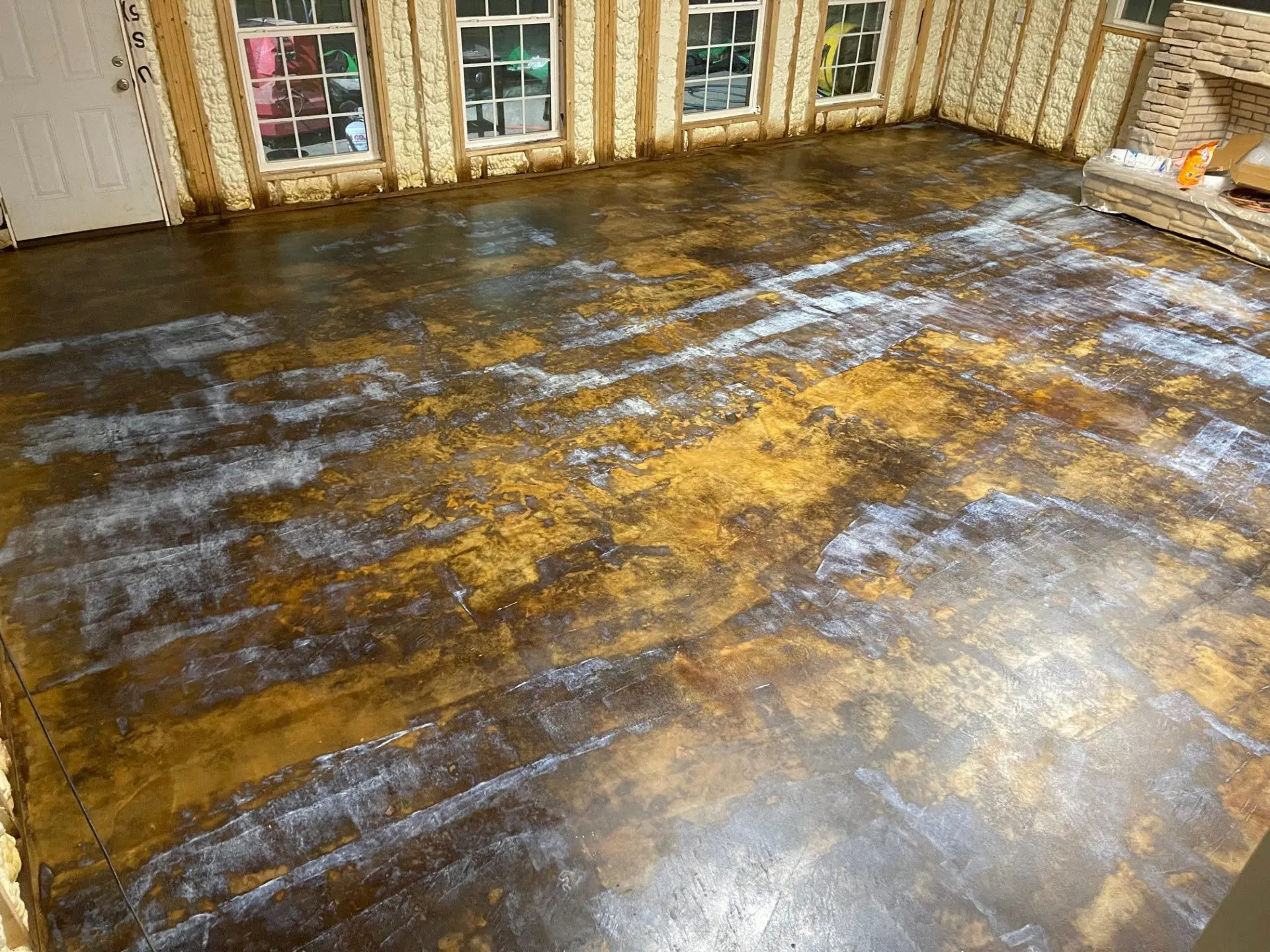 A living room floor showing a milky sealer over EverStain Black and Coffee Brown stains during the drying process.