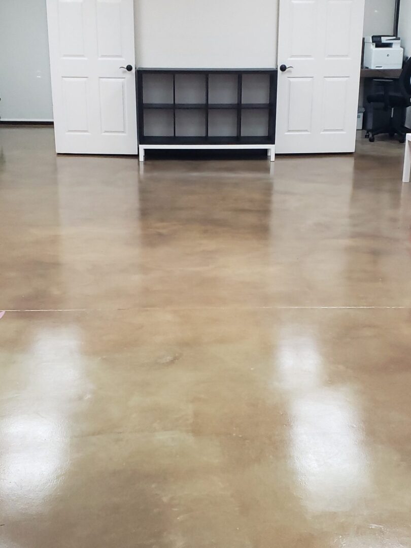 A polished concrete waiting room floor featuring warm brown and amber tones from acid staining, with subtle color variations reflecting light