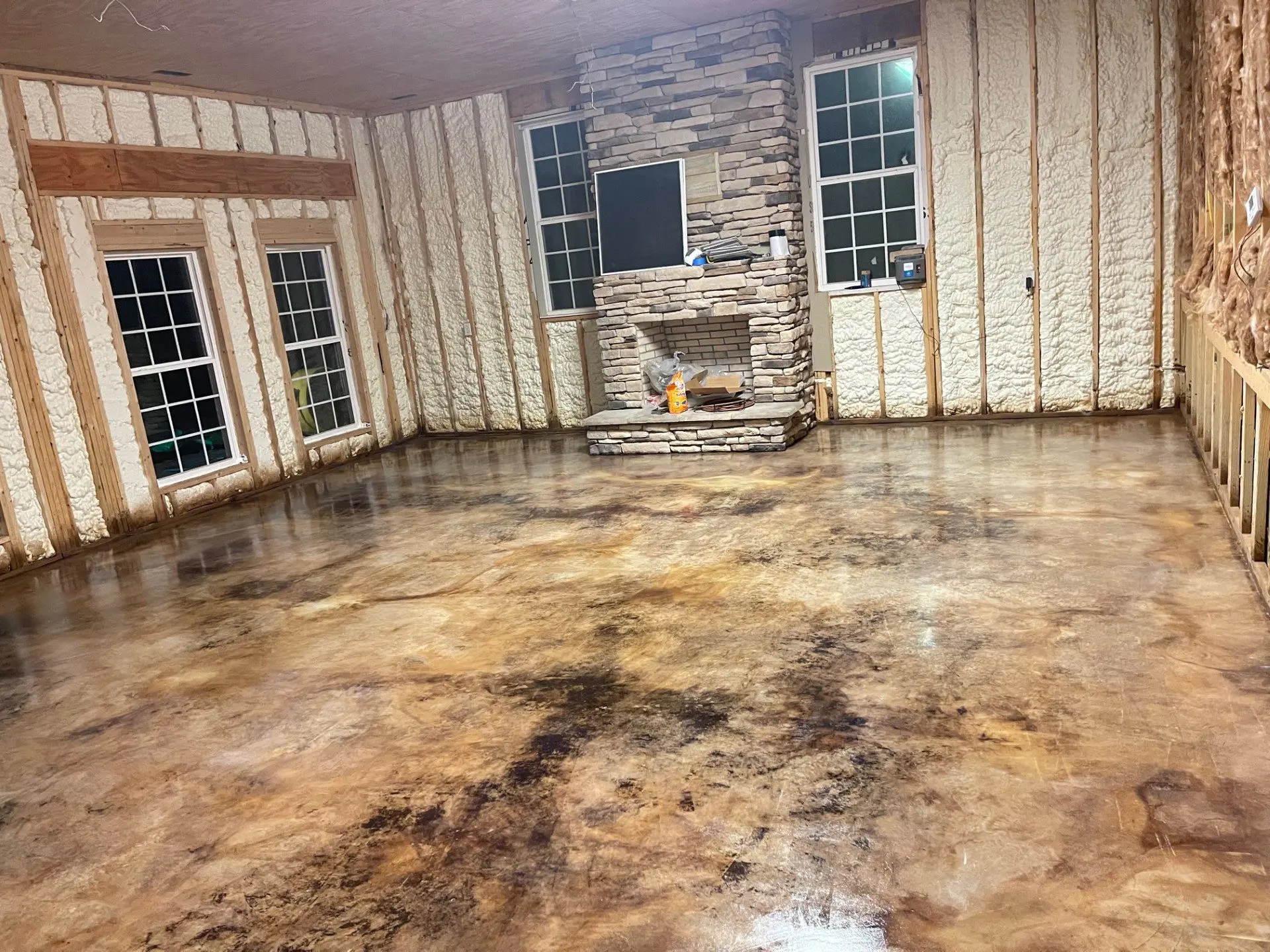 A living room floor after the sealer has dried, featuring a matte finish with worn leather-like tones in EverStain Black and Coffee Brown.