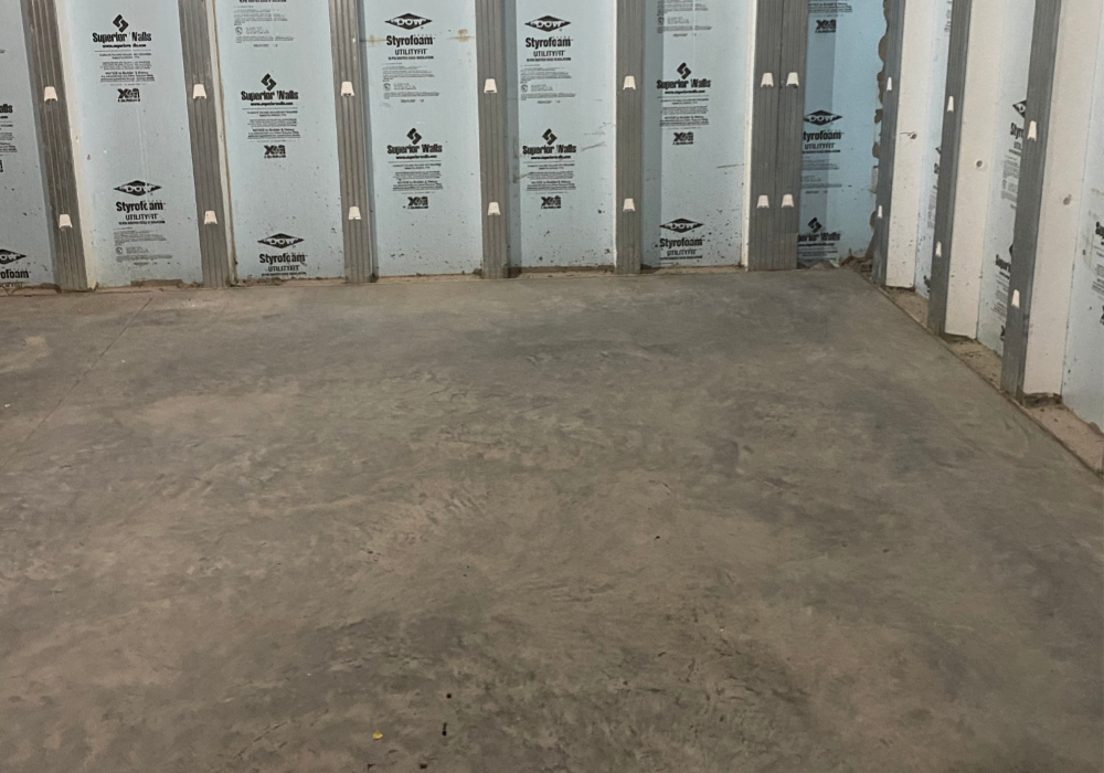 Unfinished basement with exposed insulation and untreated concrete floor